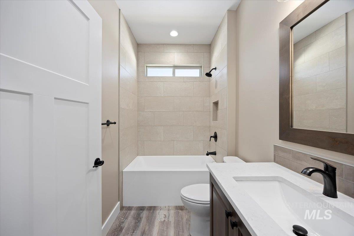 Bathroom featuring light wood-style floors, vanity, and shower / bath combination