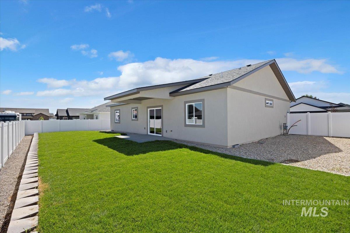 Back of house with a fenced backyard, stucco siding, and a patio