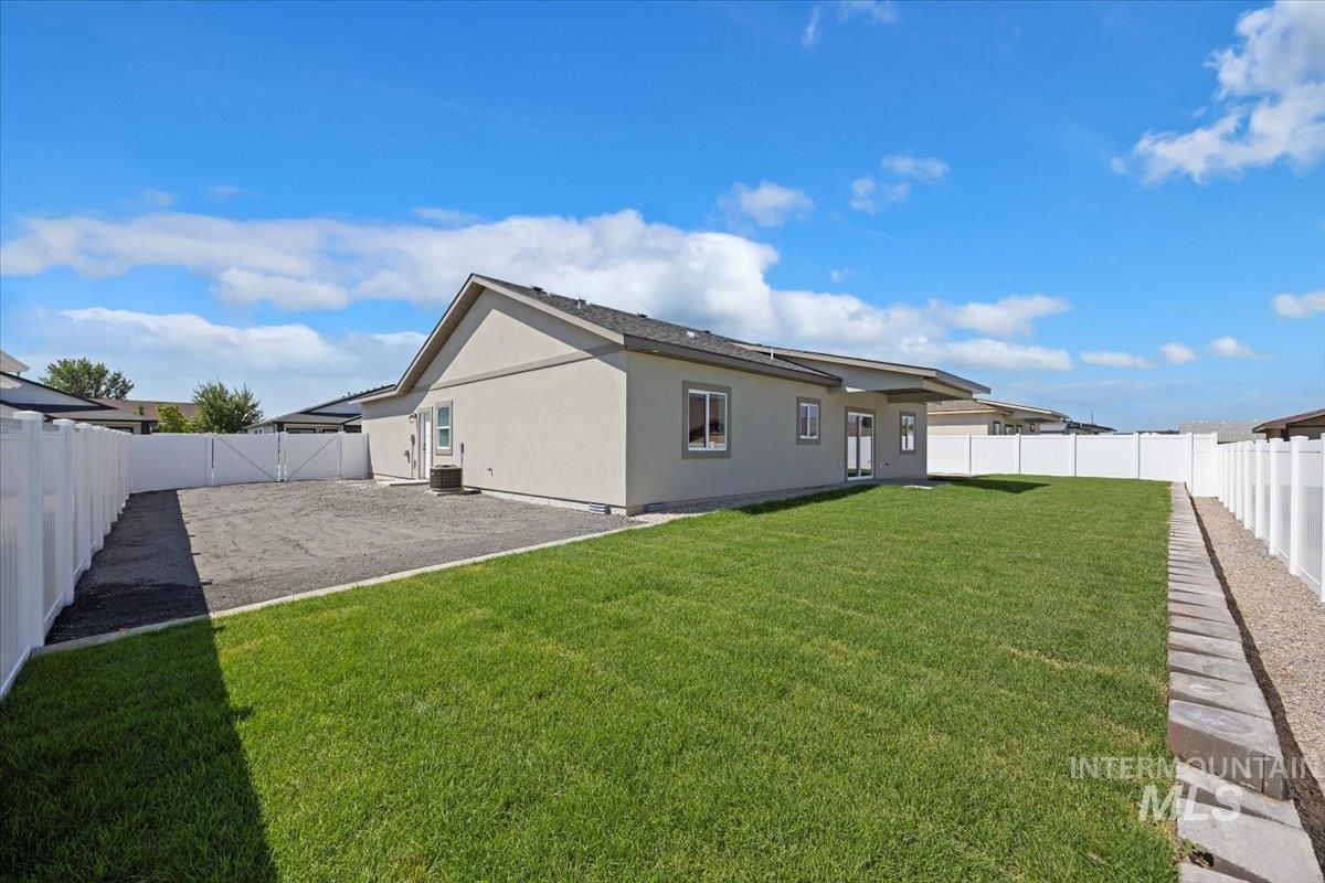 Back of house with a fenced backyard and stucco siding