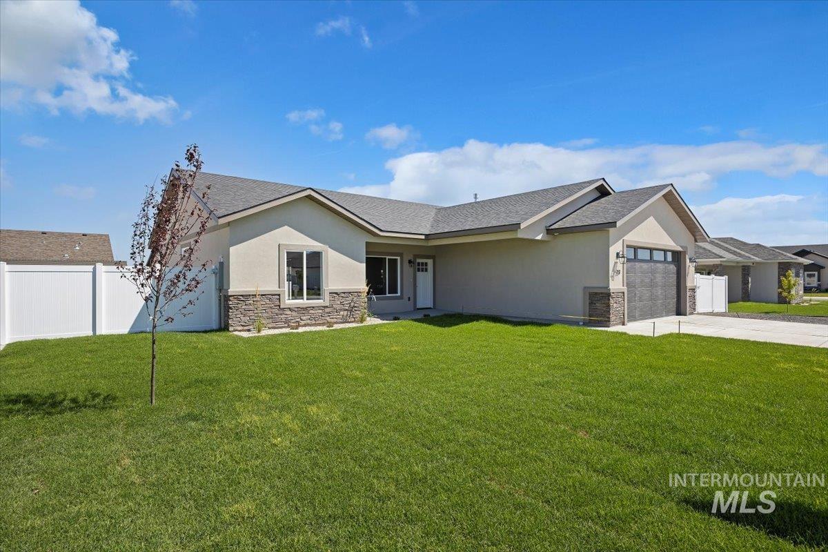 View of front of house with stone siding, stucco siding, an attached garage, and driveway