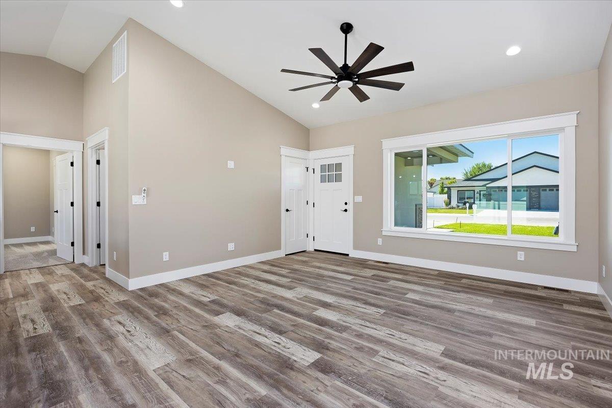 Foyer entrance featuring light wood finished floors, high vaulted ceiling, recessed lighting, and a ceiling fan