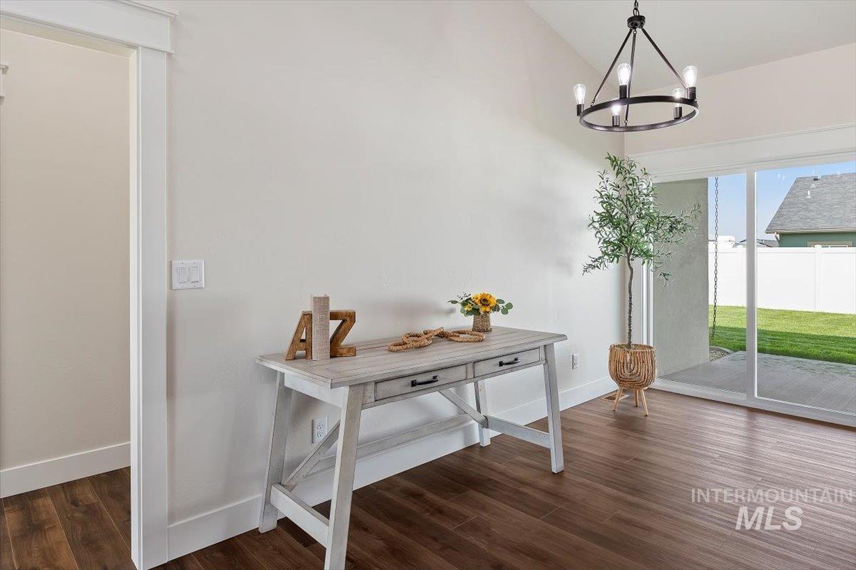 Doorway to outside with wood finished floors and a chandelier