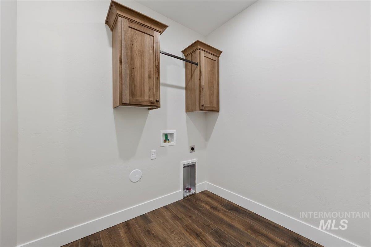 Laundry room with cabinet space, hookup for a washing machine, dark wood-style flooring, and electric dryer hookup