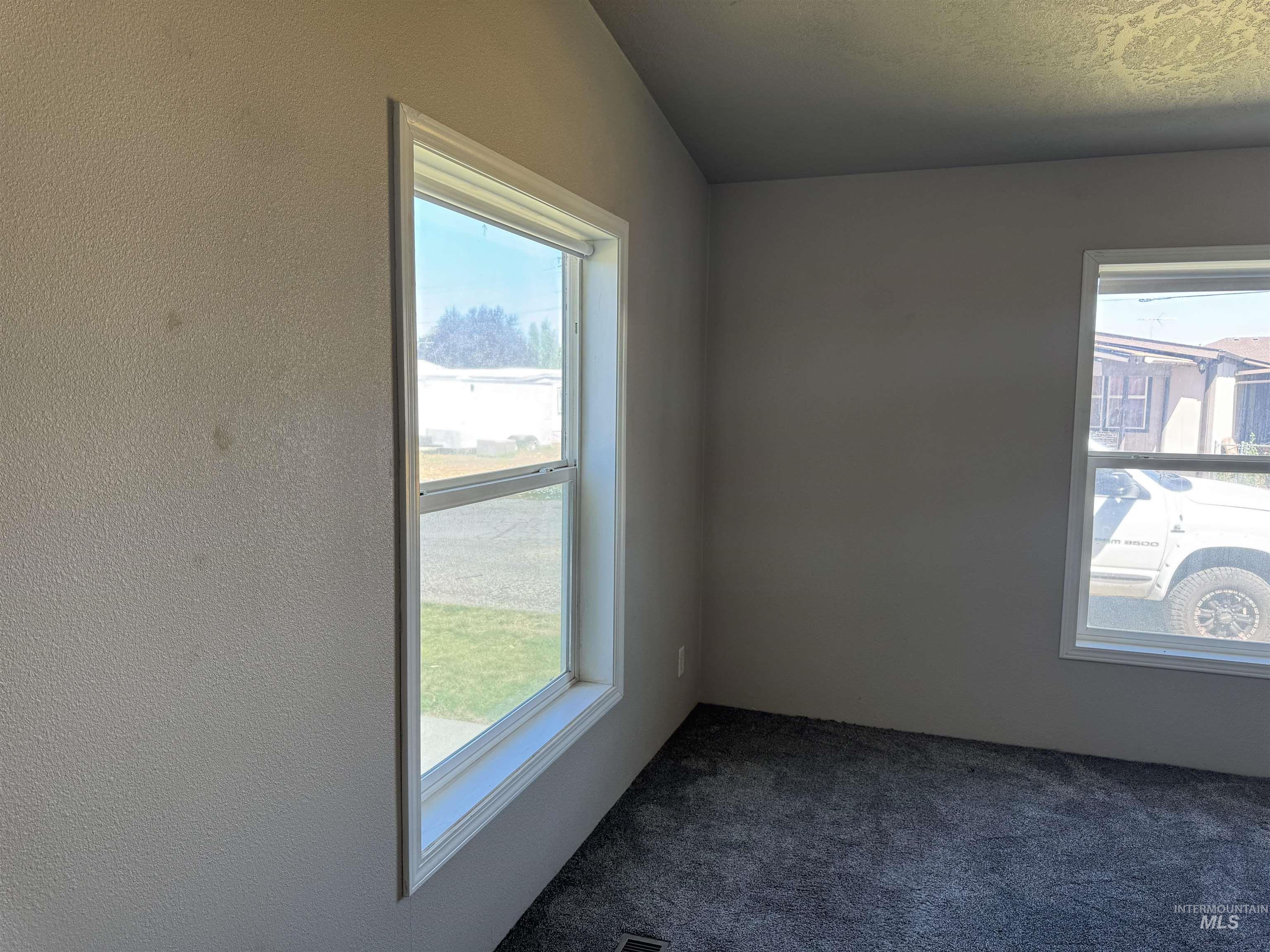Spare room with dark colored carpet