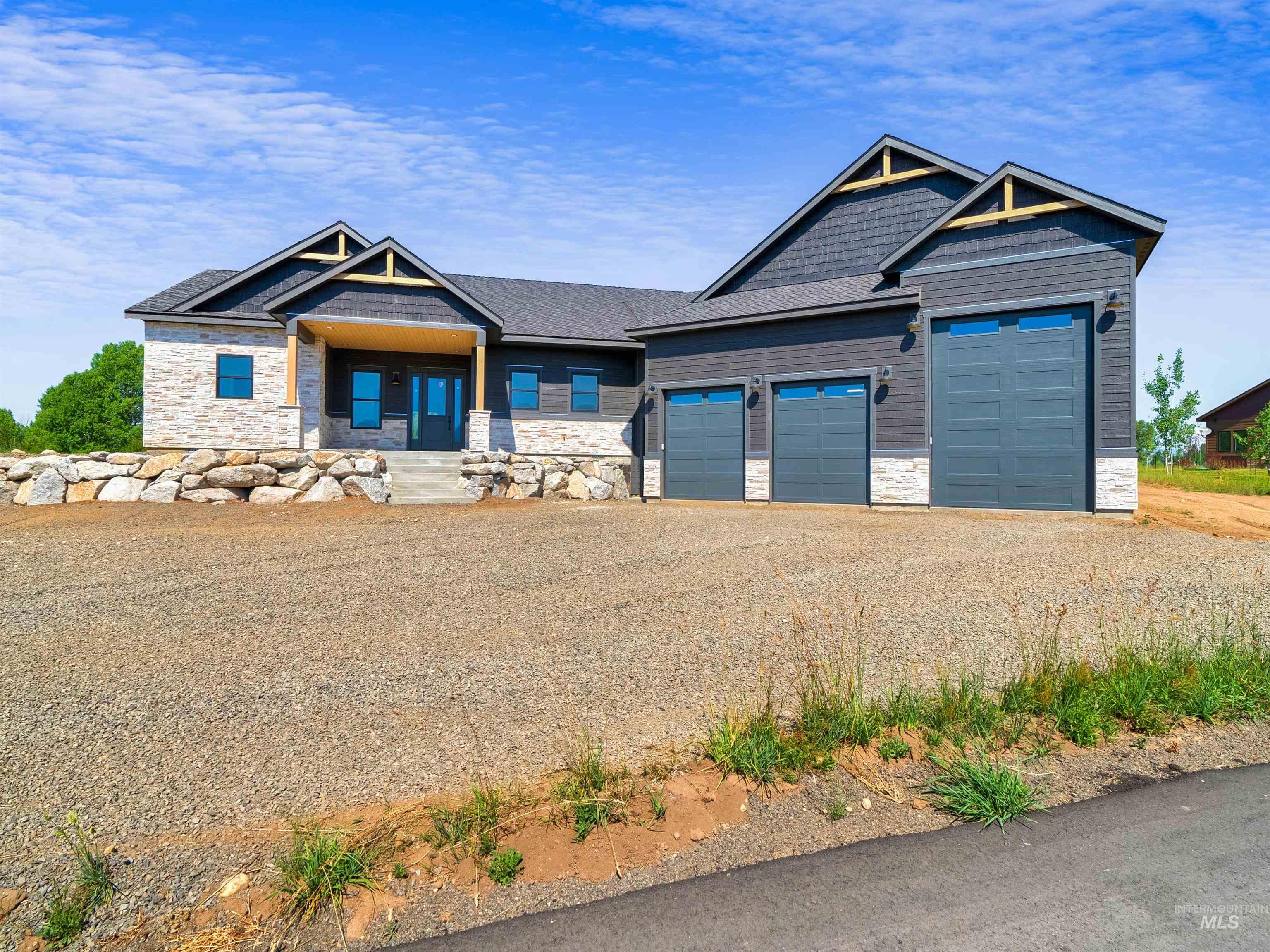 Craftsman inspired home featuring stone siding, gravel driveway, a garage, a shingled roof, and a porch
