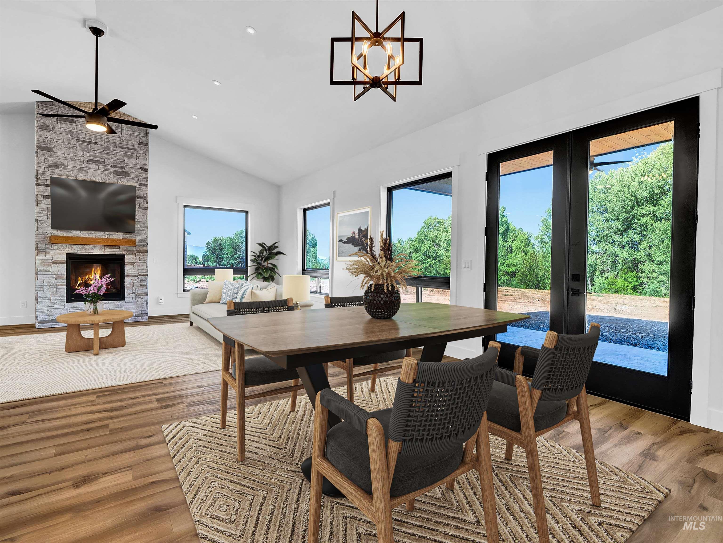 Dining area featuring a fireplace, high vaulted ceiling, light wood-style flooring, and french doors