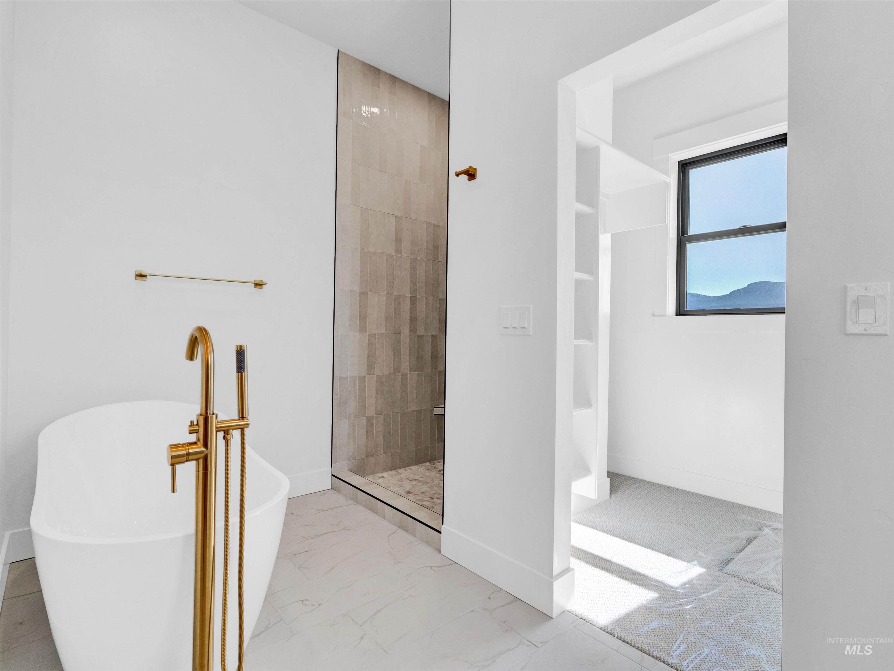 Bathroom featuring tiled shower, marble look tile flooring, and a soaking tub
