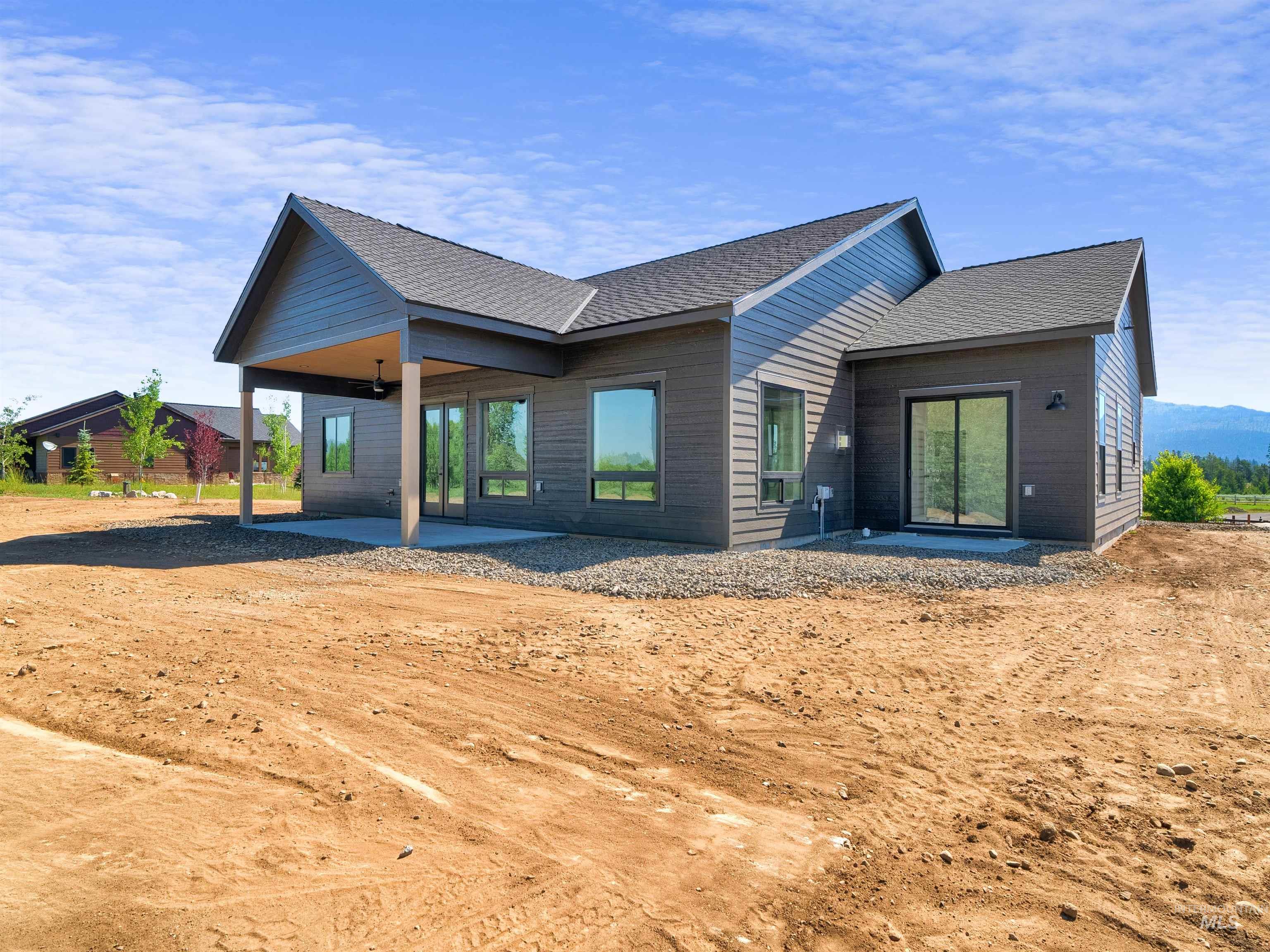 Back of house with a patio and roof with shingles