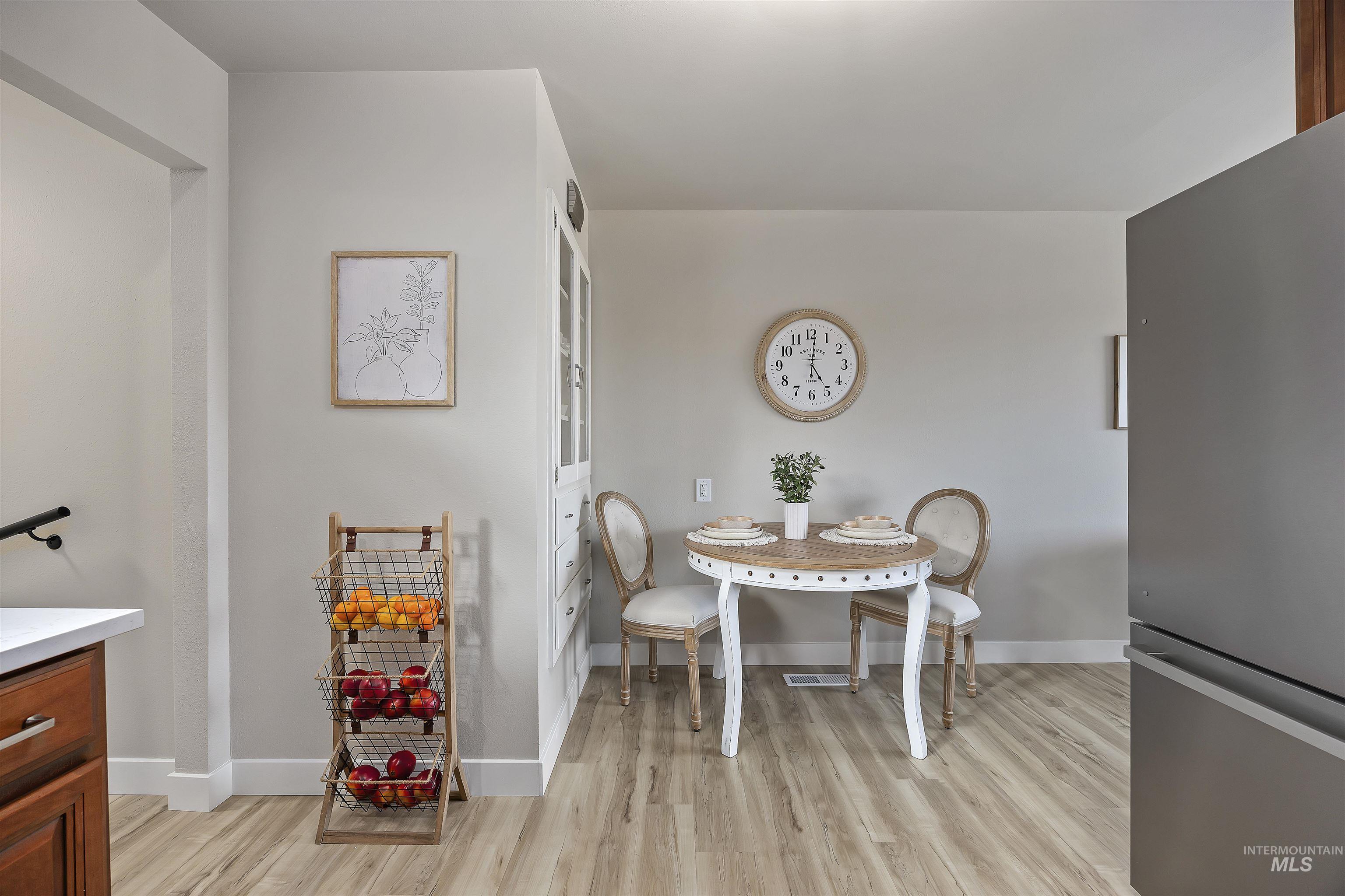 Dining area featuring light wood-type flooring and baseboards