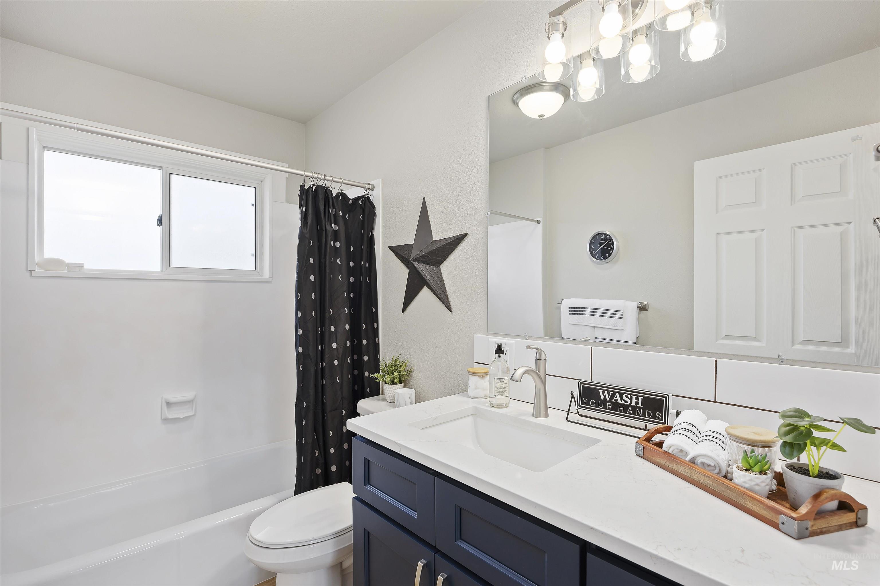 Full bath featuring shower / bath combo with shower curtain and vanity