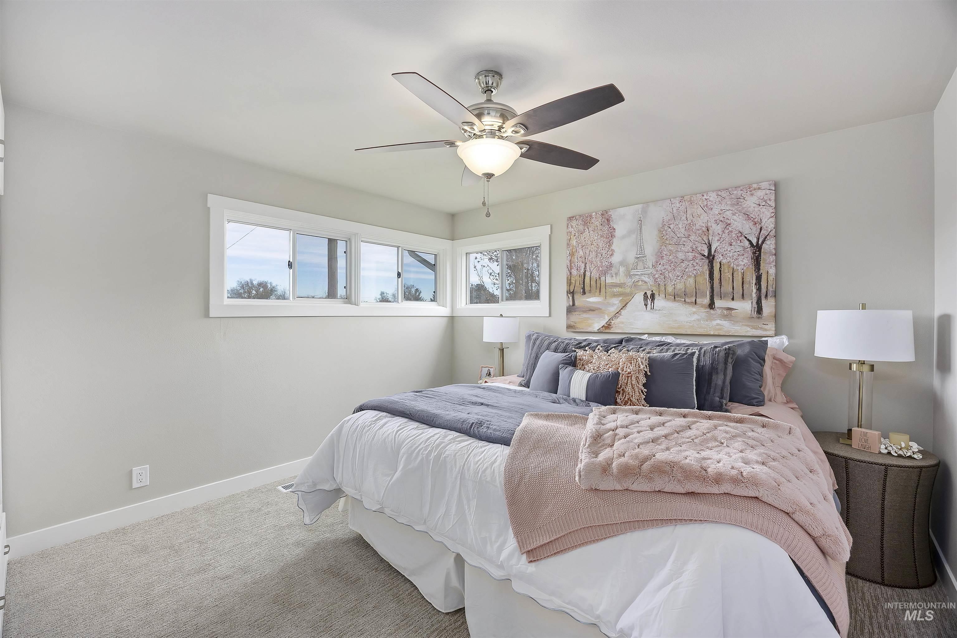 Carpeted bedroom featuring baseboards and ceiling fan