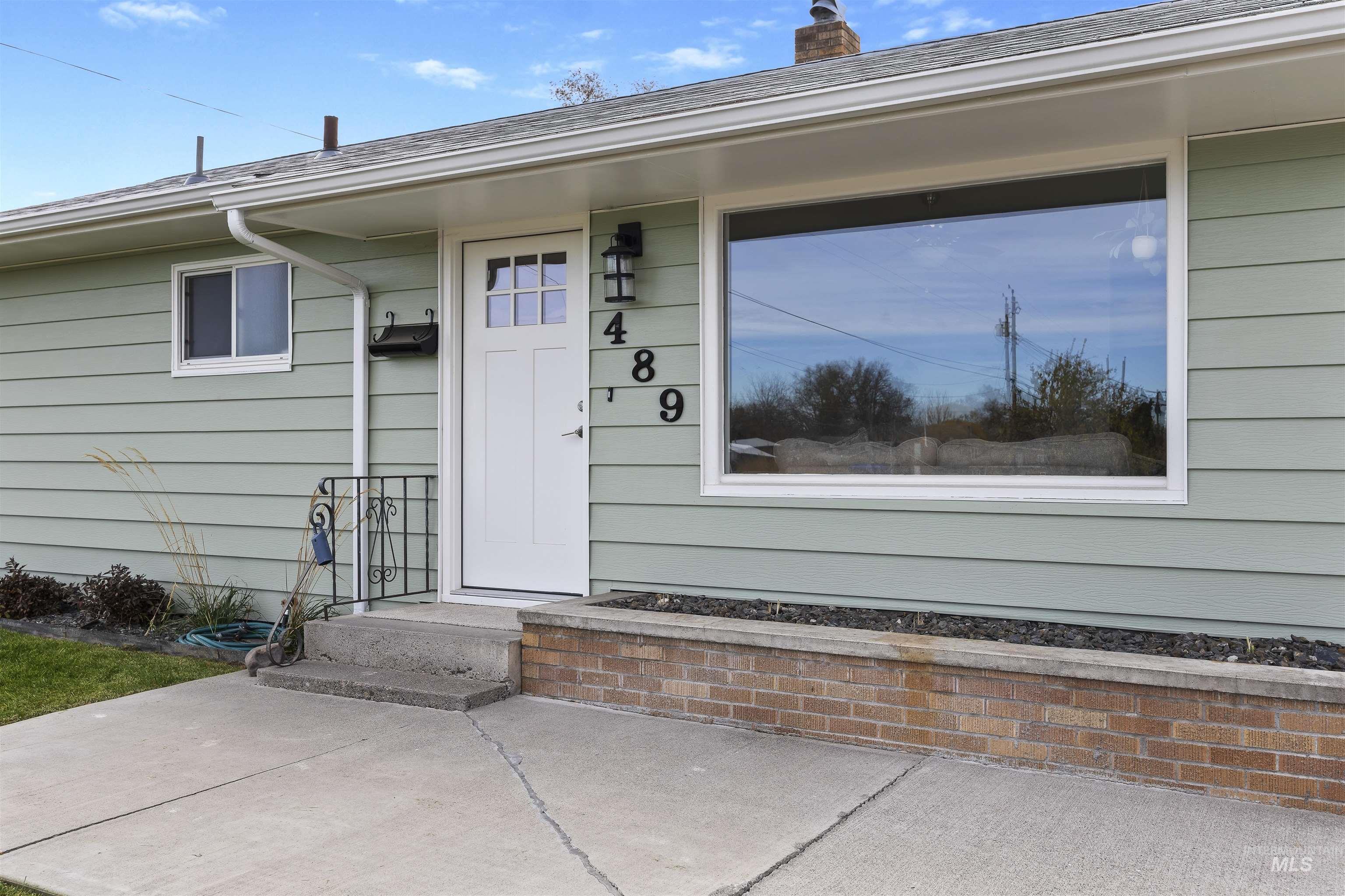 Property entrance with a chimney and roof with shingles
