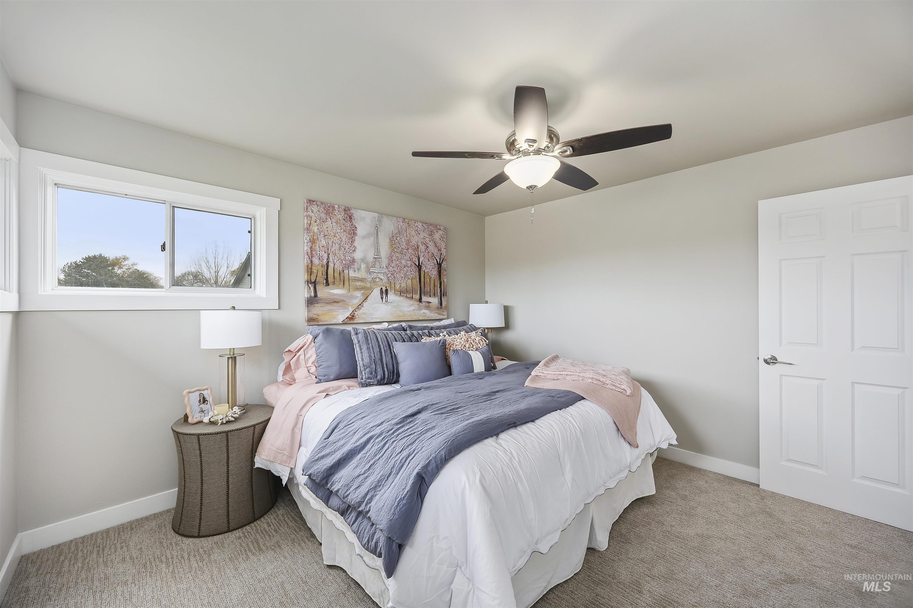 Carpeted bedroom with a ceiling fan and baseboards