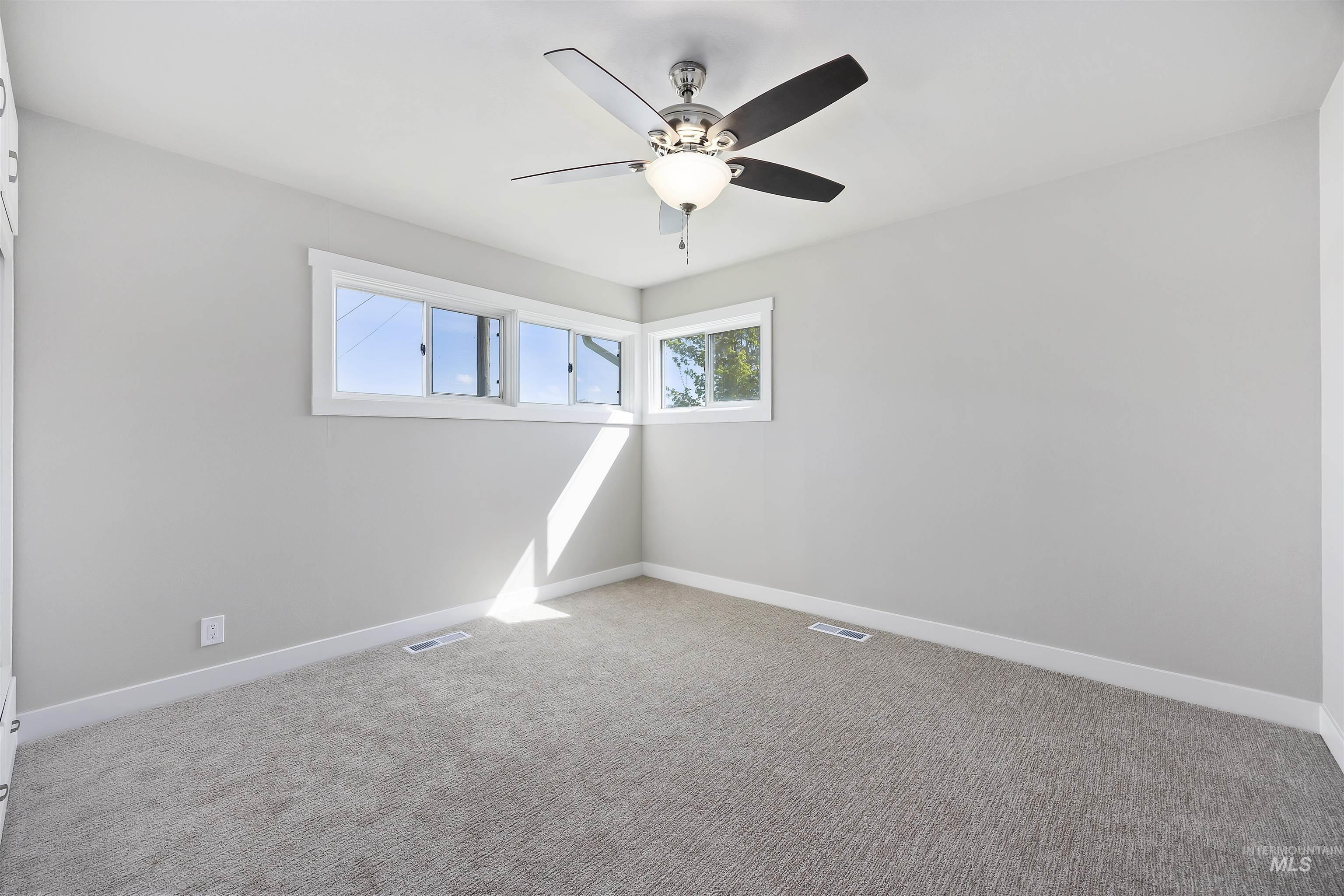 Empty room with carpet flooring and ceiling fan