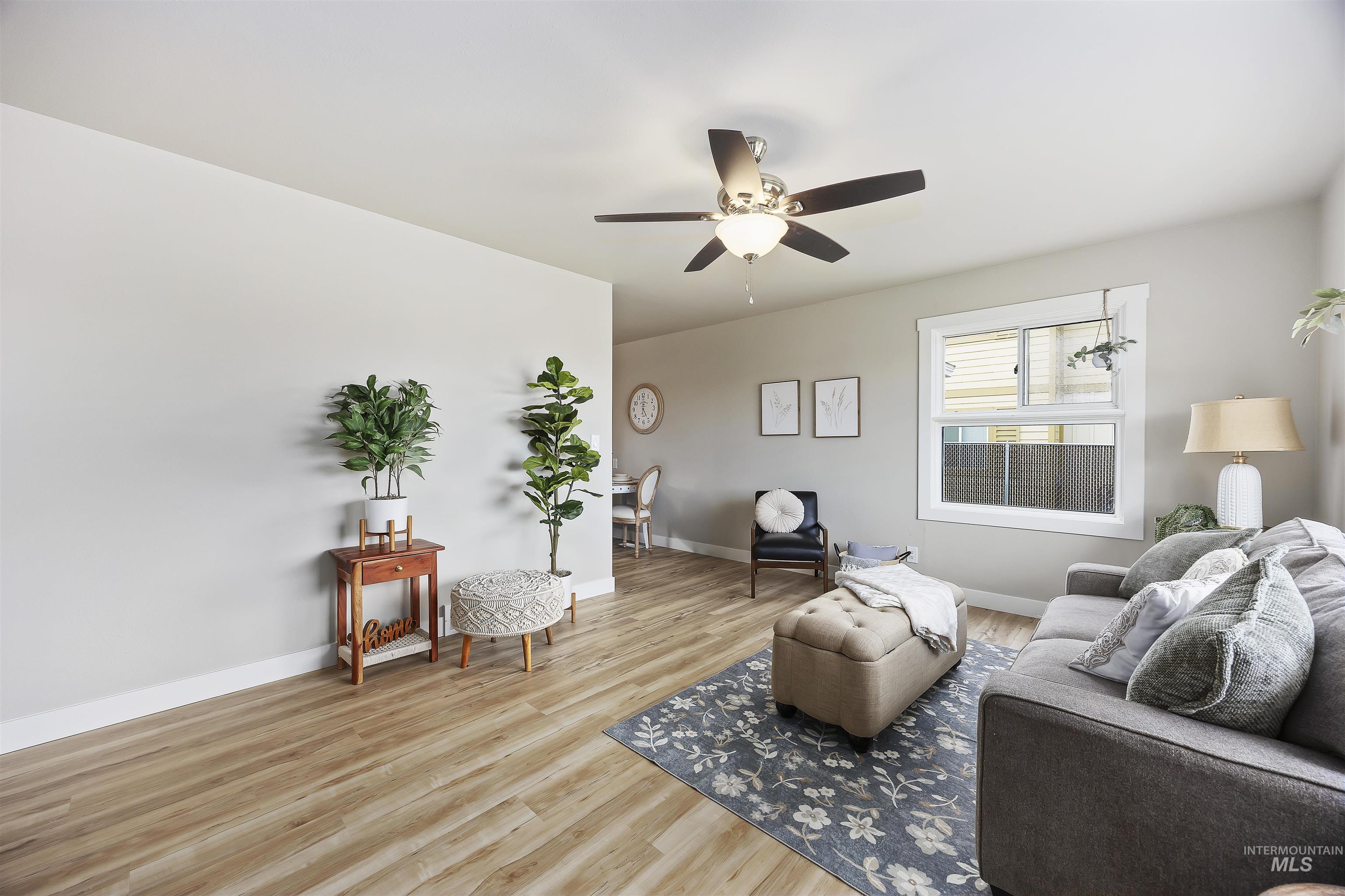 Living room with light wood-type flooring and a ceiling fan