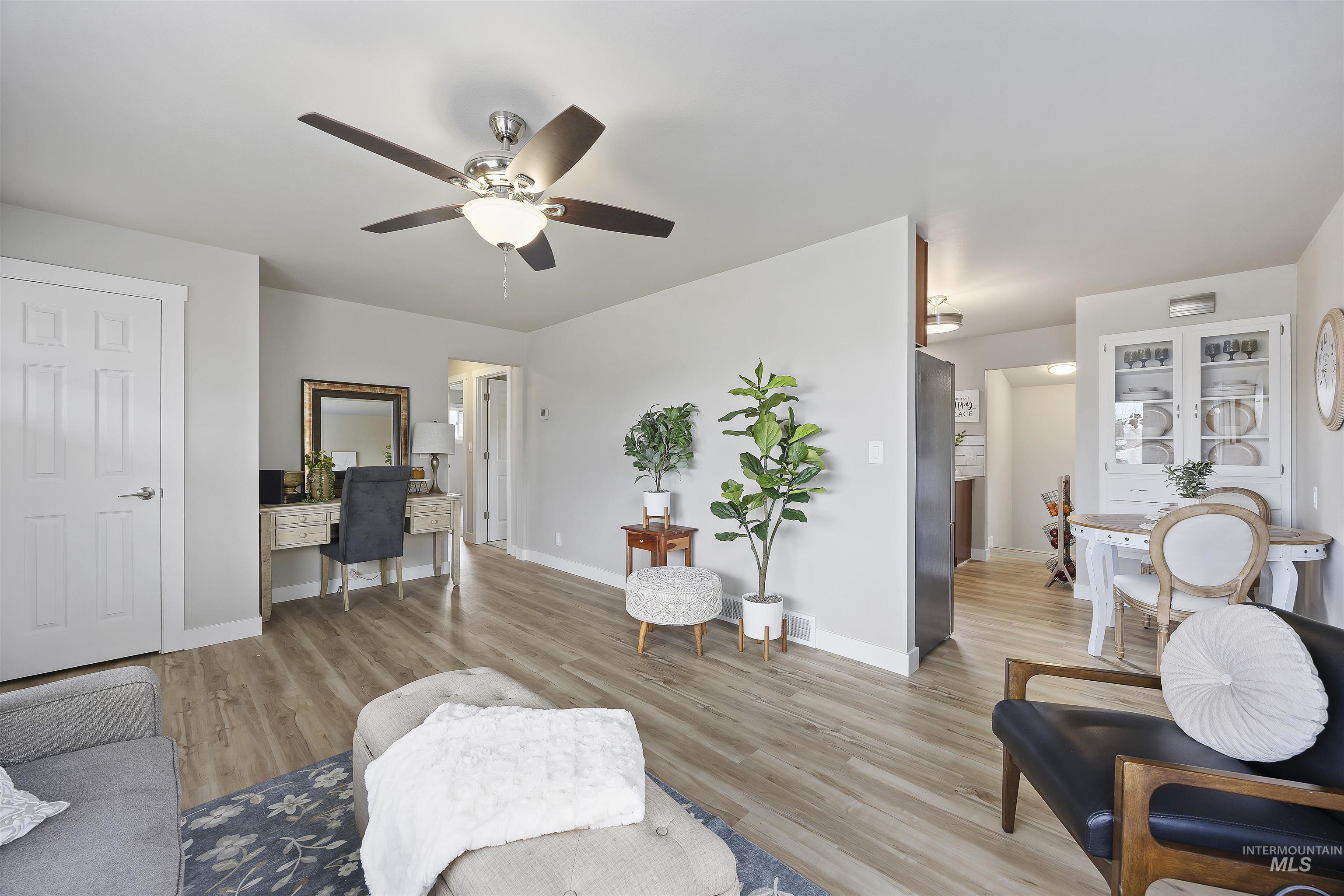 Living area with light wood-style floors, a ceiling fan, and an office area