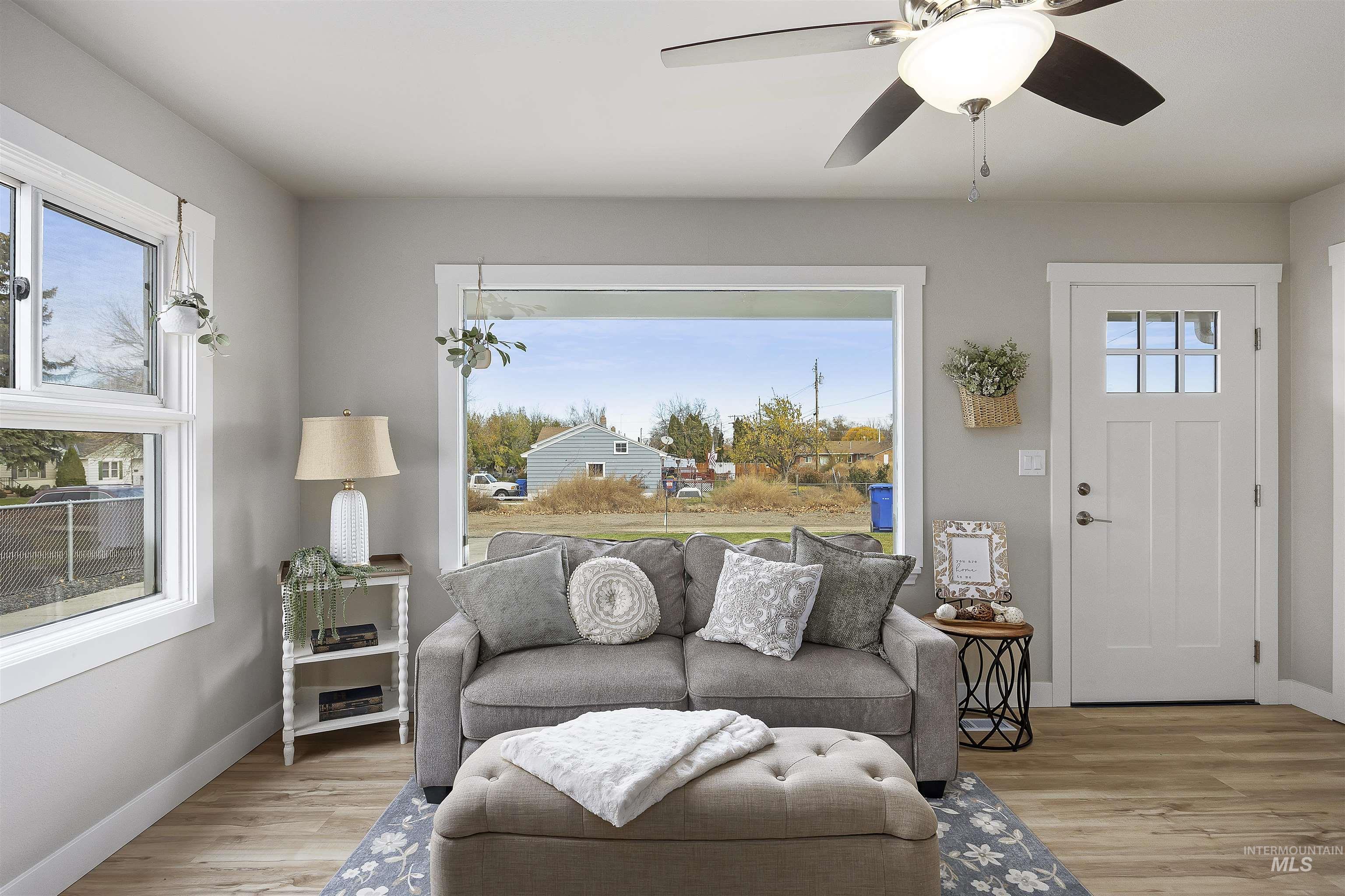 Living area with light wood-type flooring and a ceiling fan