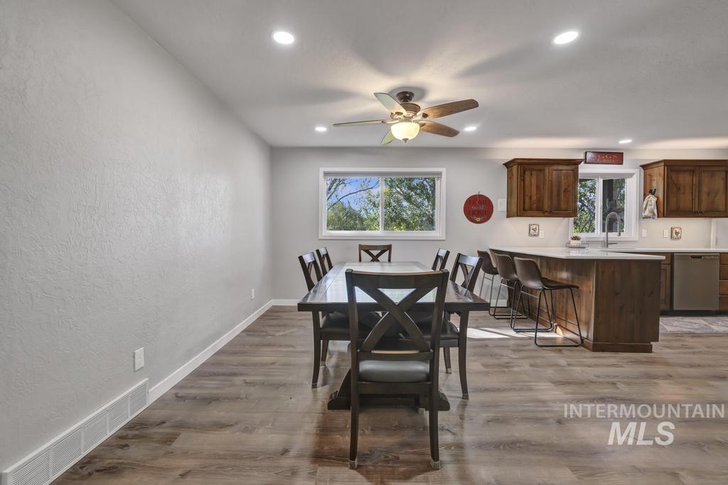 Dining area featuring a textured wall, light wood-style flooring, plenty of natural light, a ceiling fan, and recessed lighting