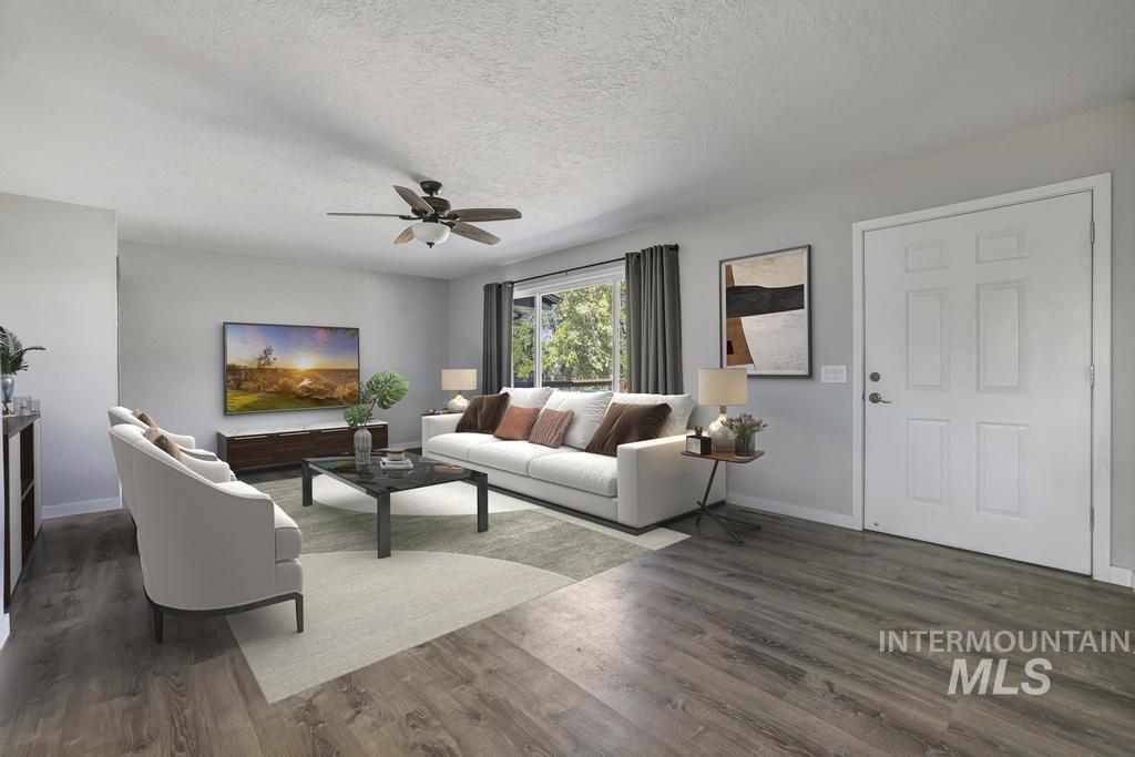 Living area featuring a textured ceiling, dark wood-style flooring, and a ceiling fan