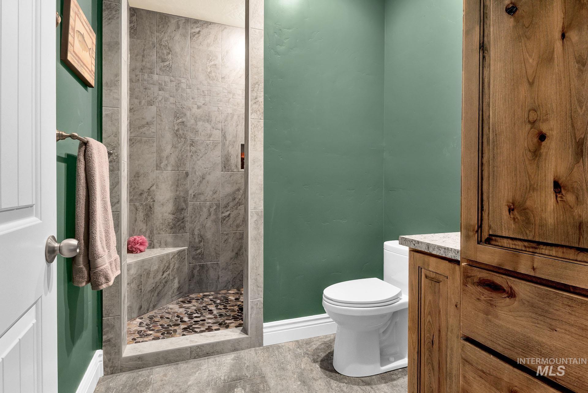Bath attached to bedroom suite with extra built in cabinetry and tiled walk in shower