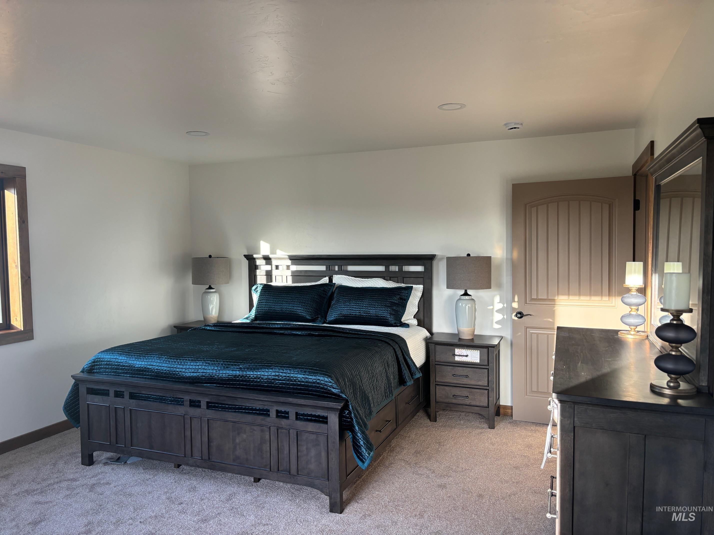 Bedroom featuring light colored carpet and baseboards