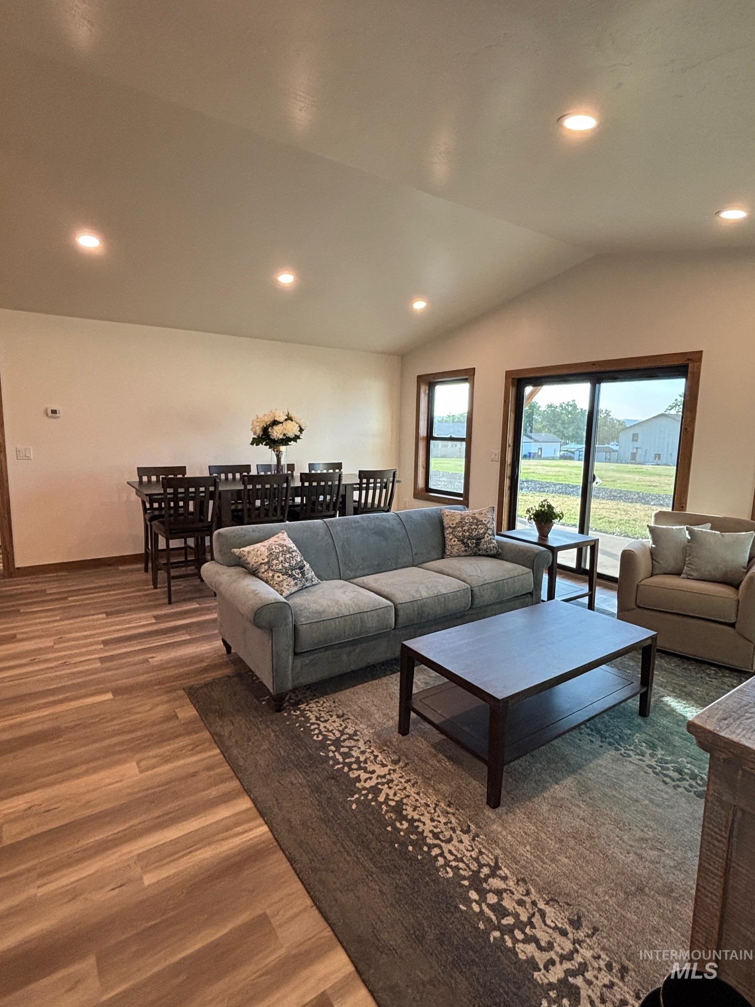 Living room featuring wood finished floors, recessed lighting, and lofted ceiling