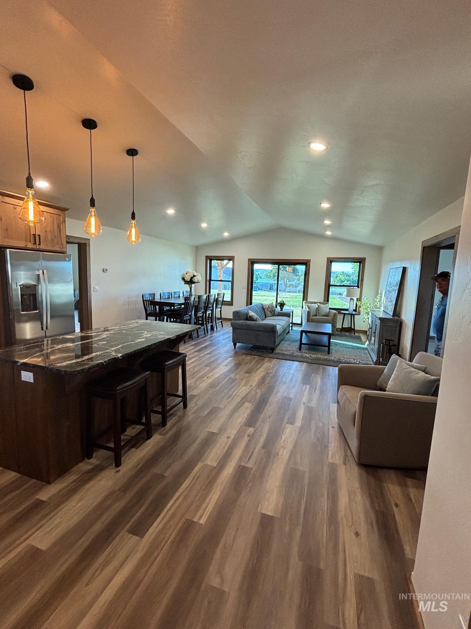 Living area featuring lofted ceiling, dark wood finished floors, and recessed lighting