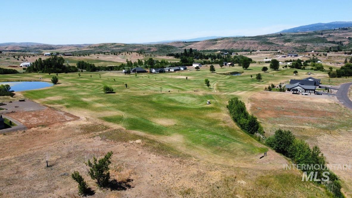 Aerial view of a golf course and a water and mountain view