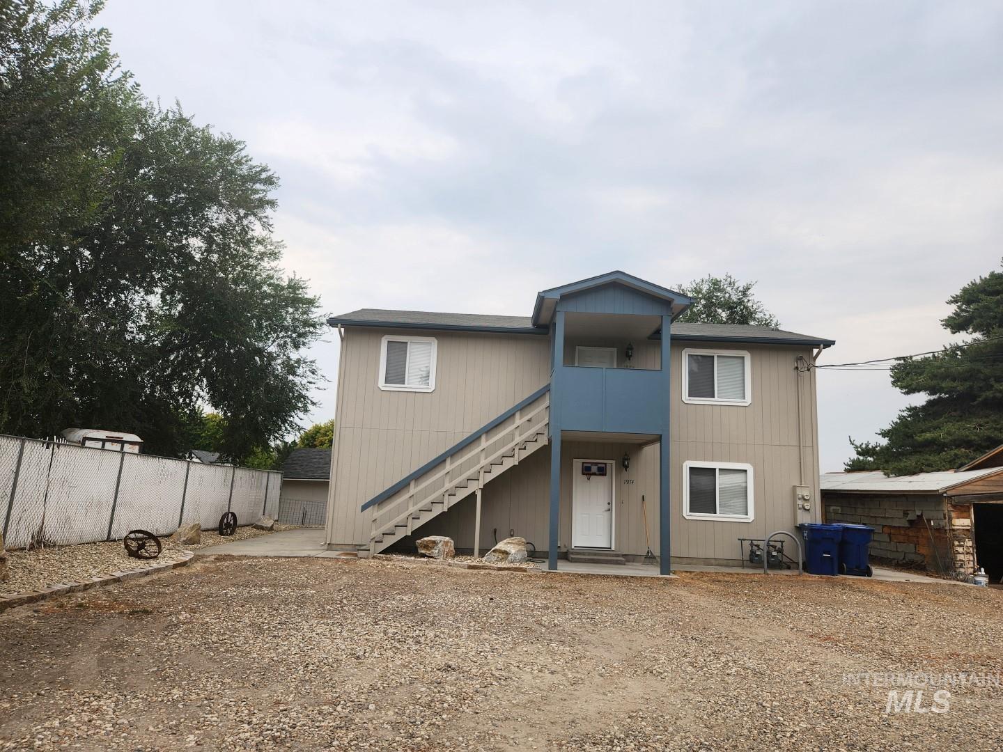 Back of house with stairway, a patio, and a balcony
