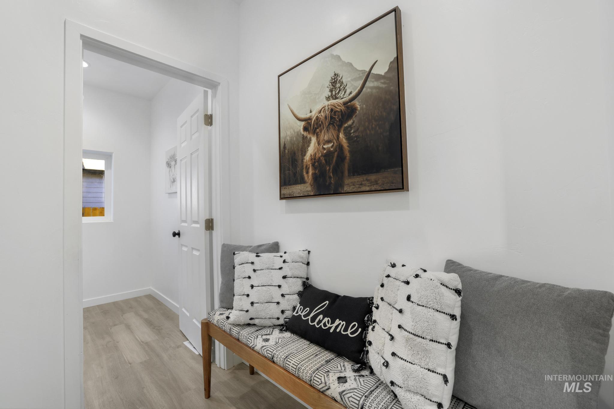 Hallway featuring light wood-type flooring and baseboards