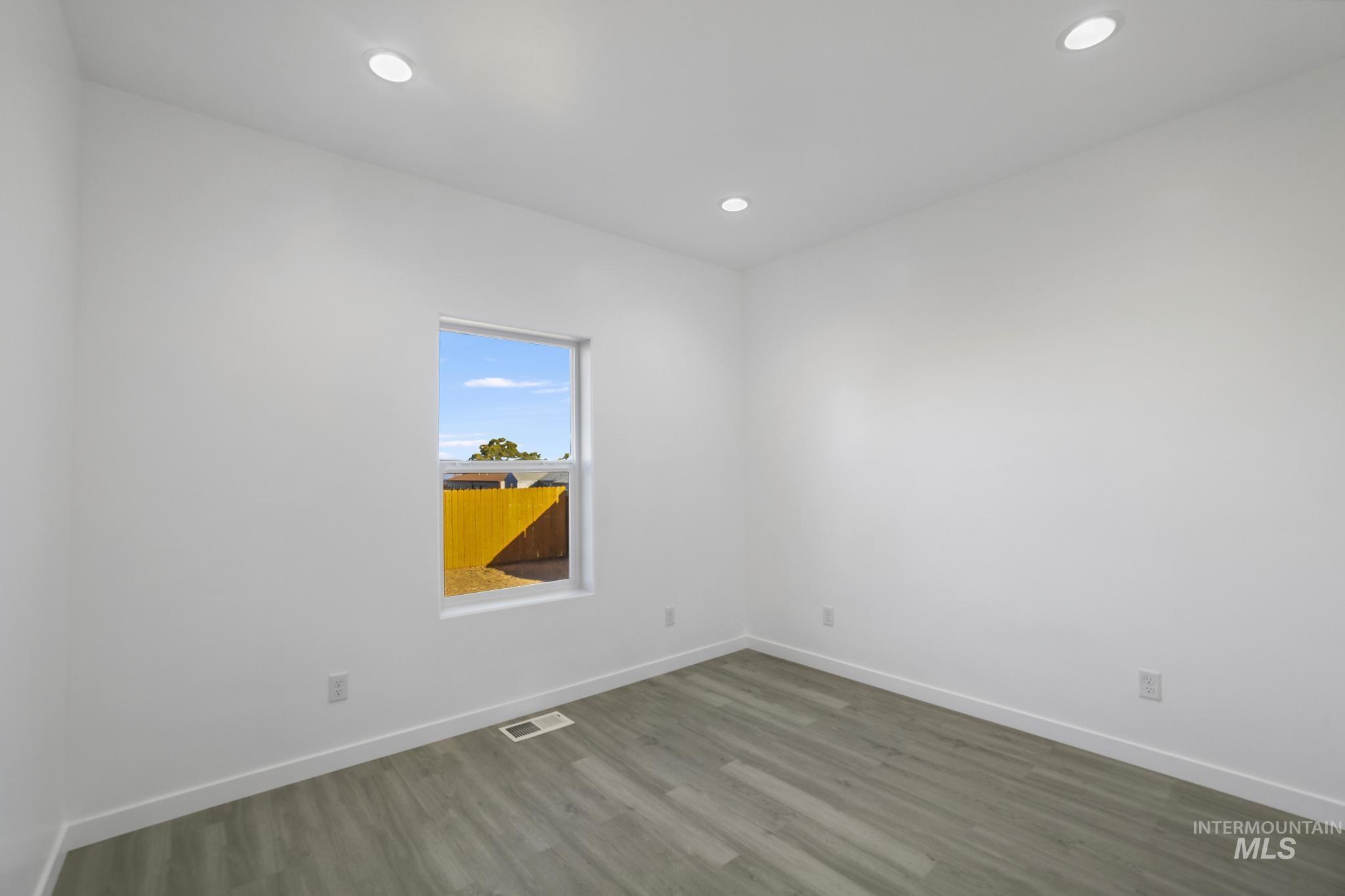 Empty room featuring wood finished floors and recessed lighting
