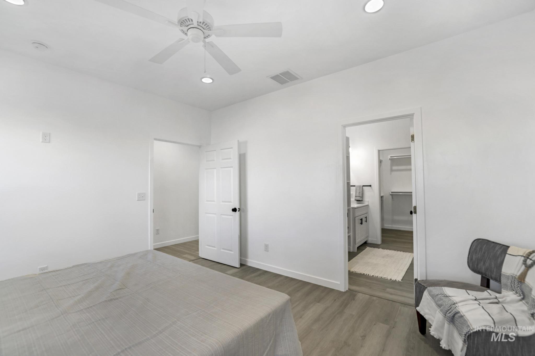 Bedroom with recessed lighting, light wood-style floors, a ceiling fan, and connected bathroom
