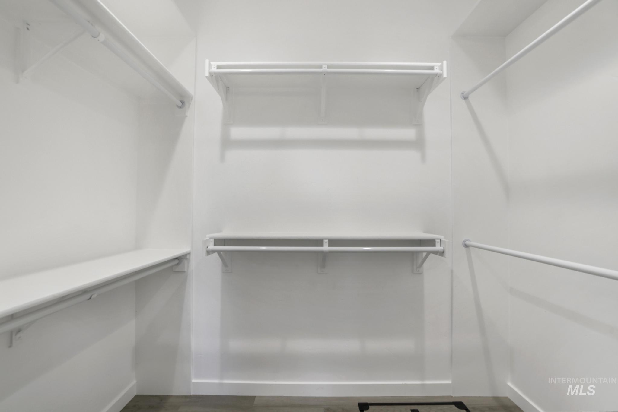 Walk in closet with wood finished floors