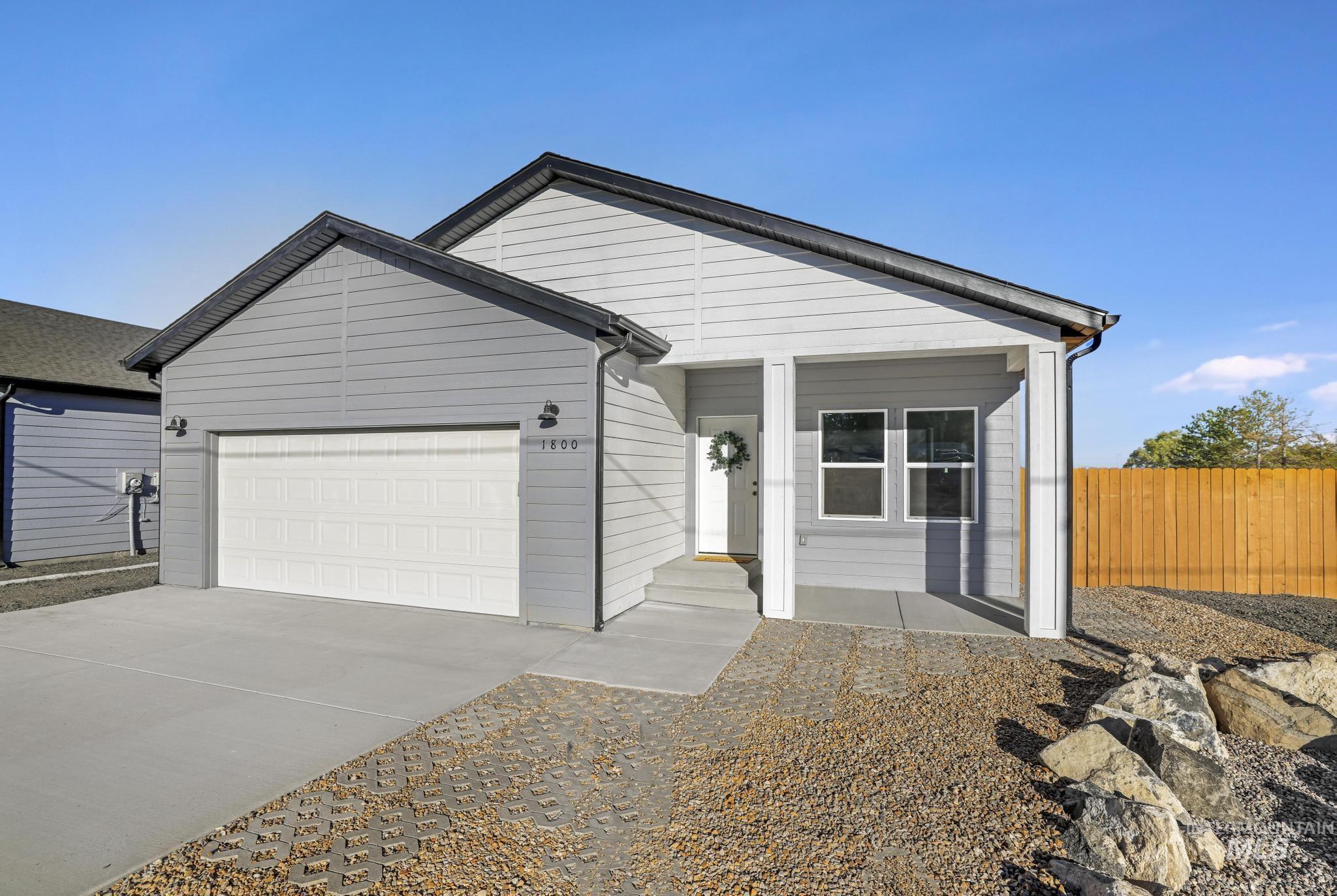 View of front facade featuring concrete driveway and a garage