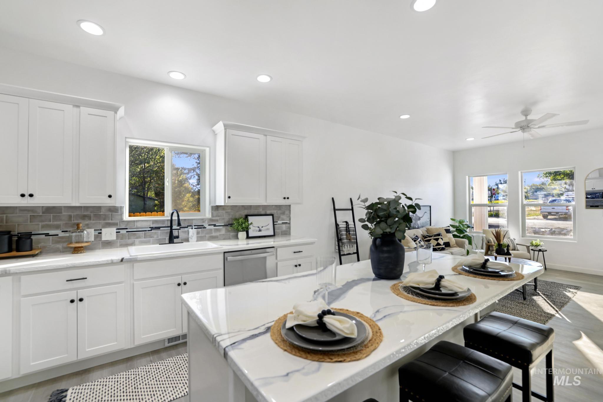 Kitchen featuring white cabinetry, recessed lighting, backsplash, dishwasher, and light stone countertops