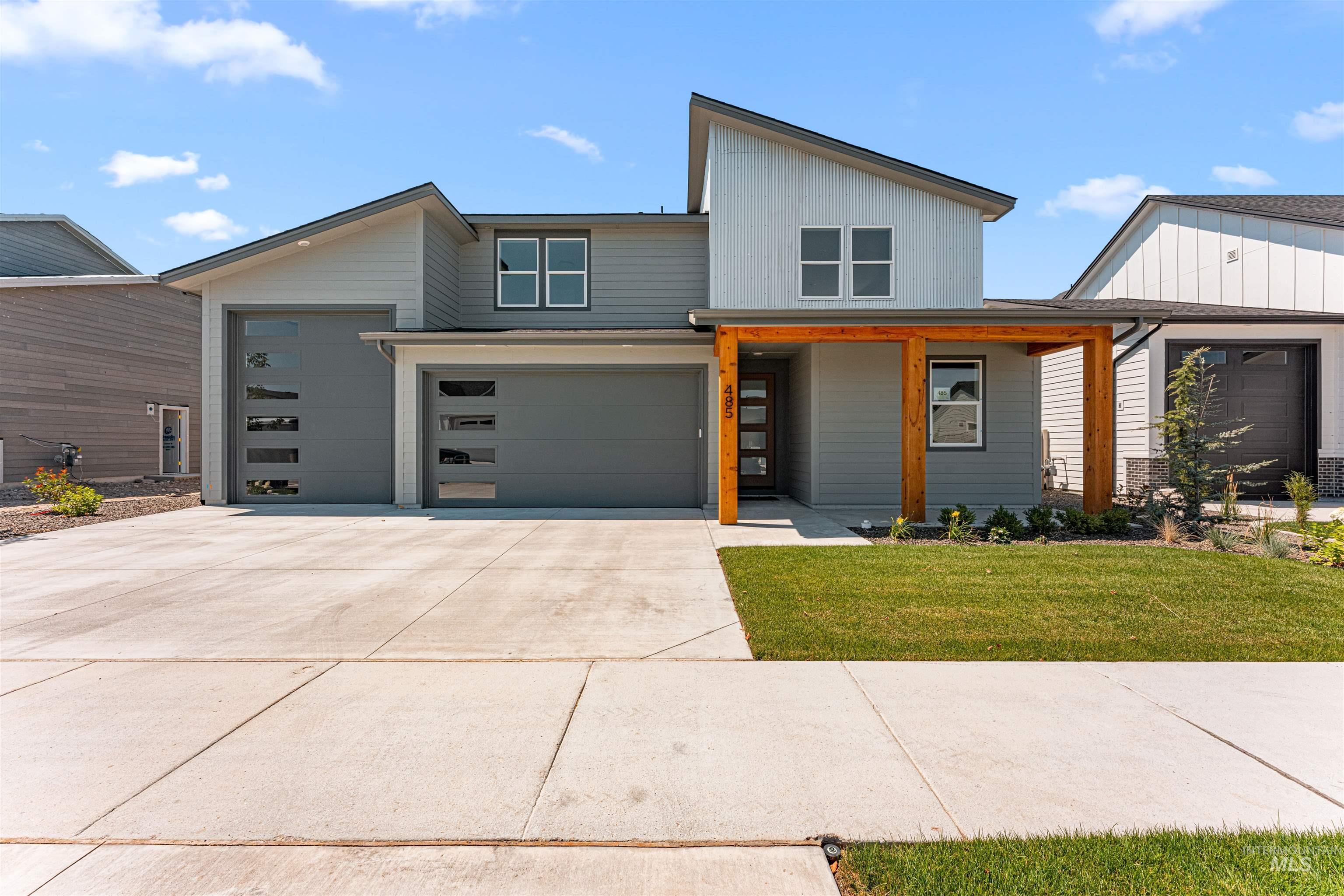 Contemporary home featuring a front yard, driveway, and an attached garage