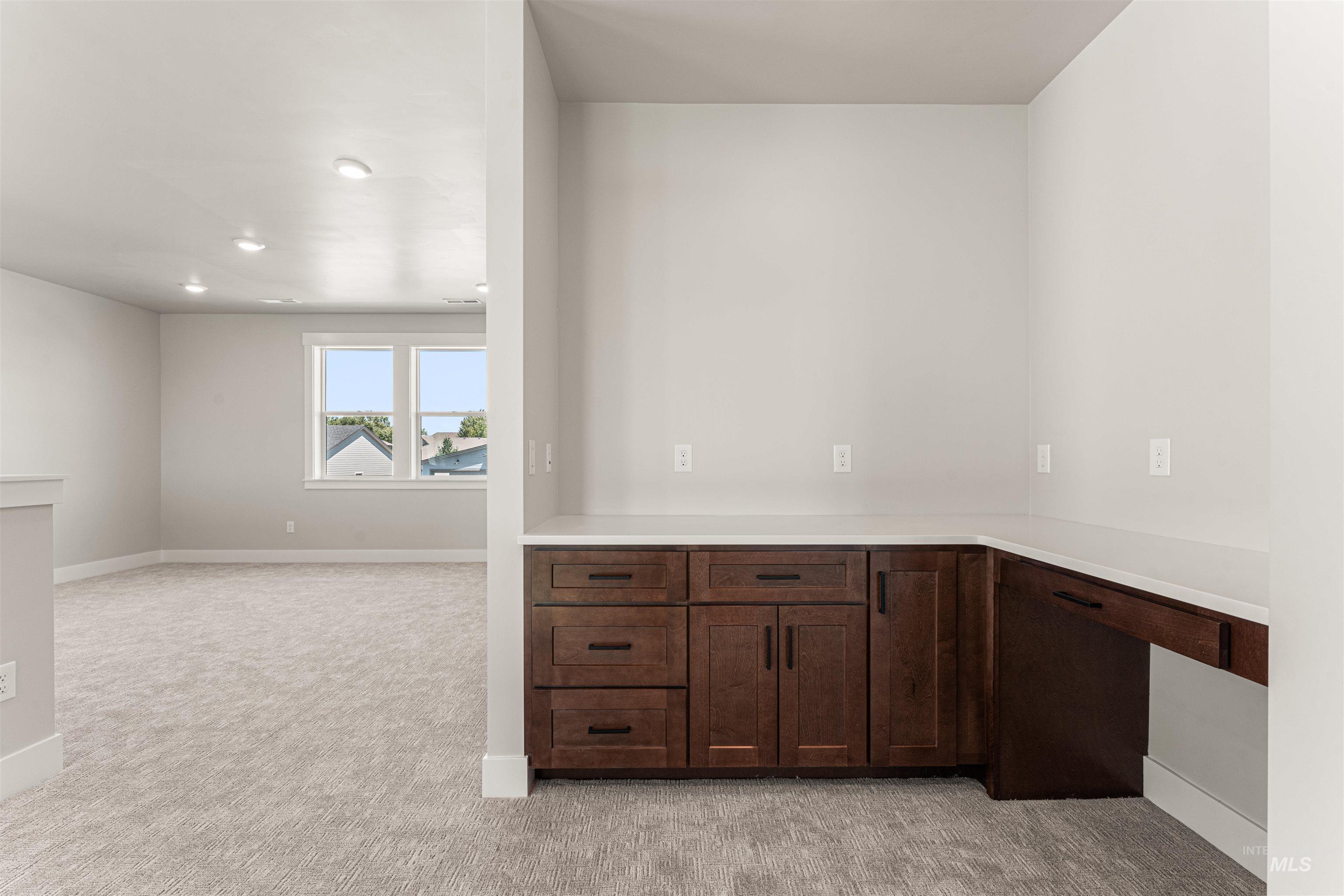 Bar with light colored carpet, recessed lighting, and built in desk