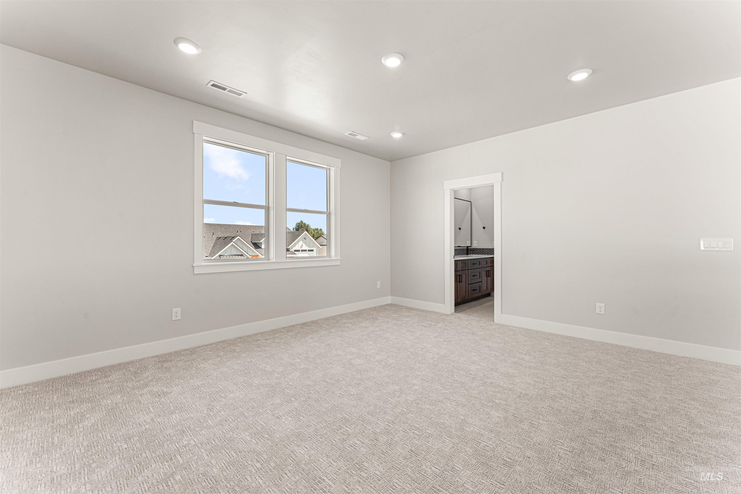 Empty room featuring light colored carpet and recessed lighting