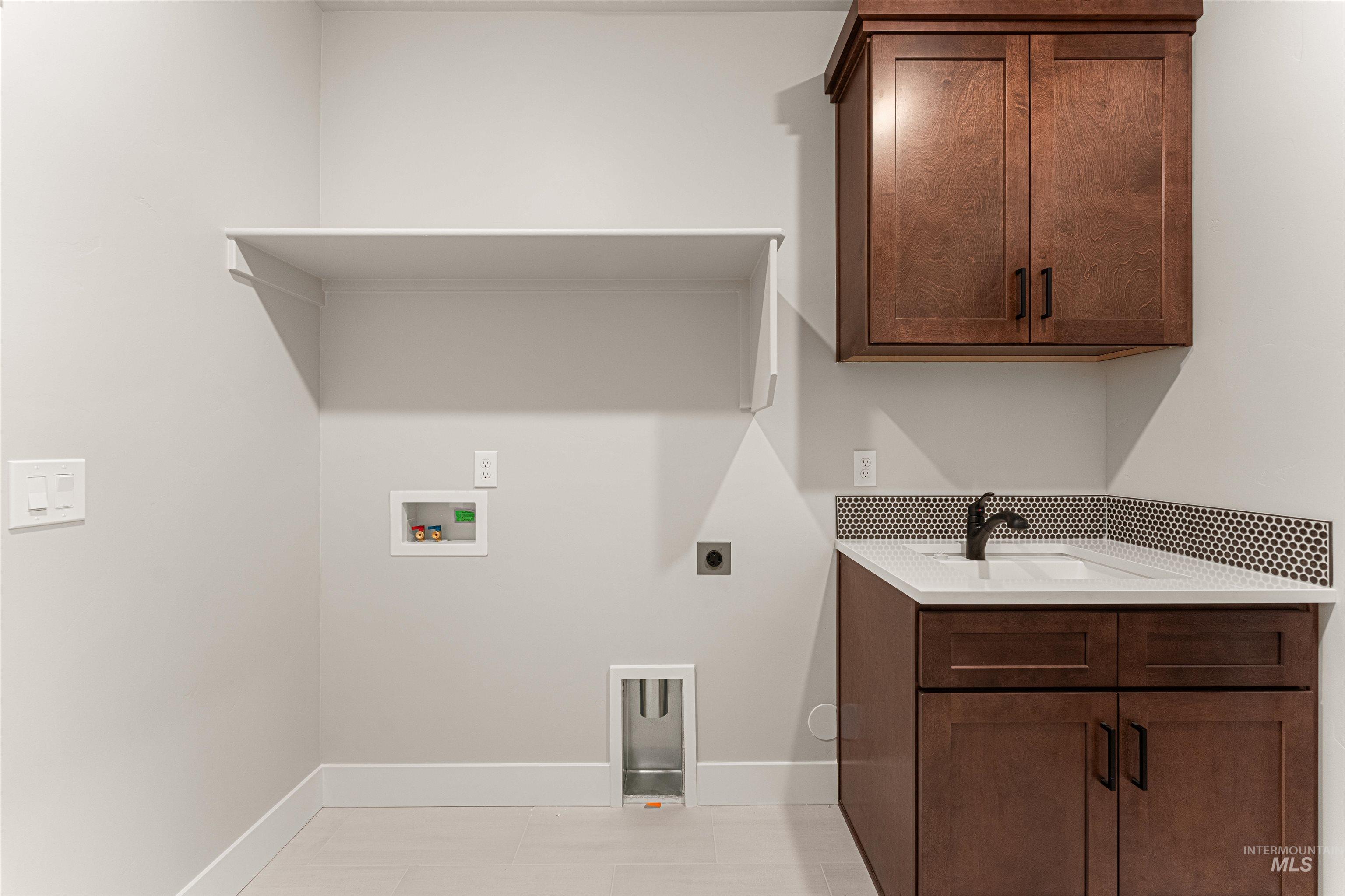Laundry area with hookup for an electric dryer, washer hookup, and cabinet space