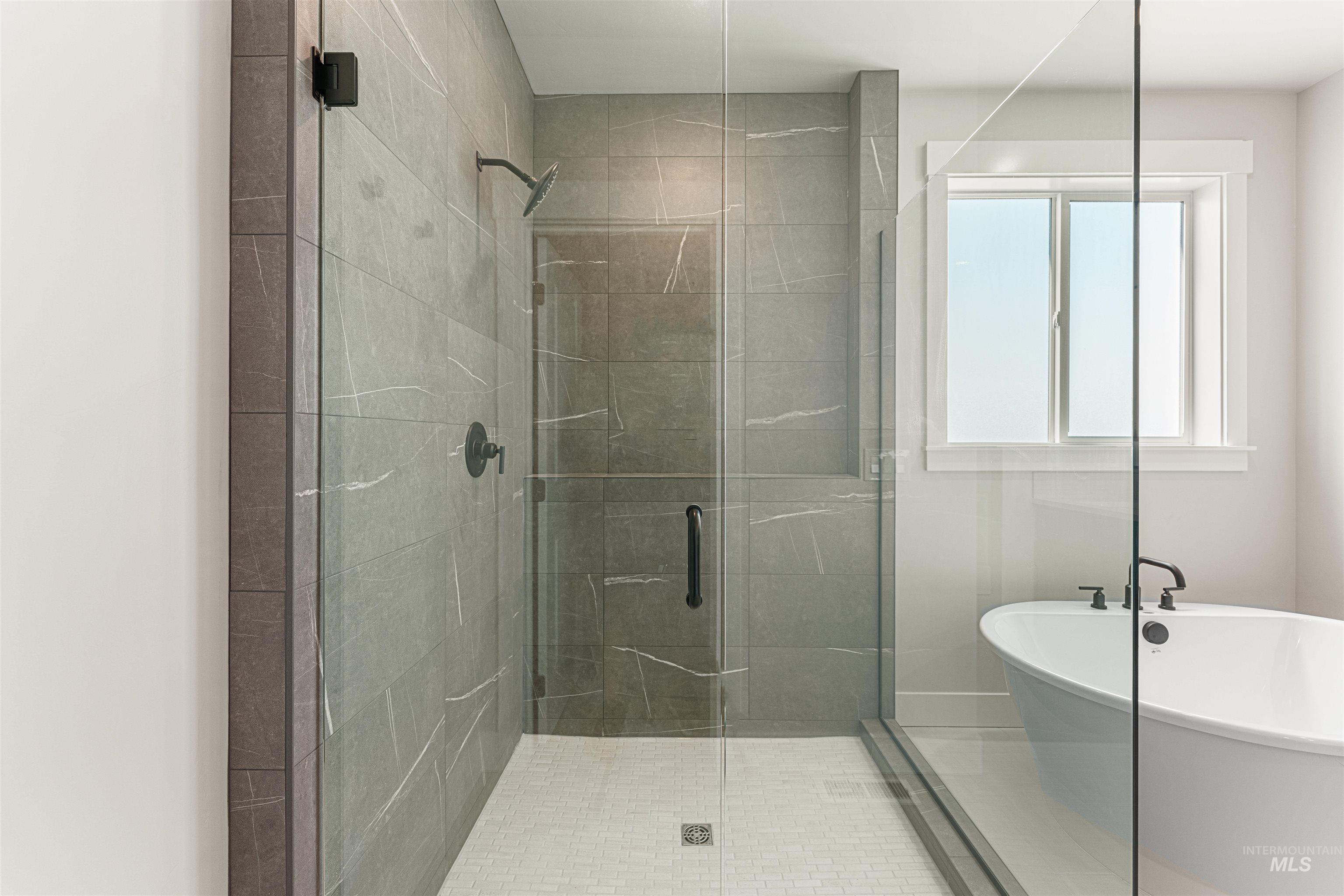 Full bath with a shower stall and a freestanding bath