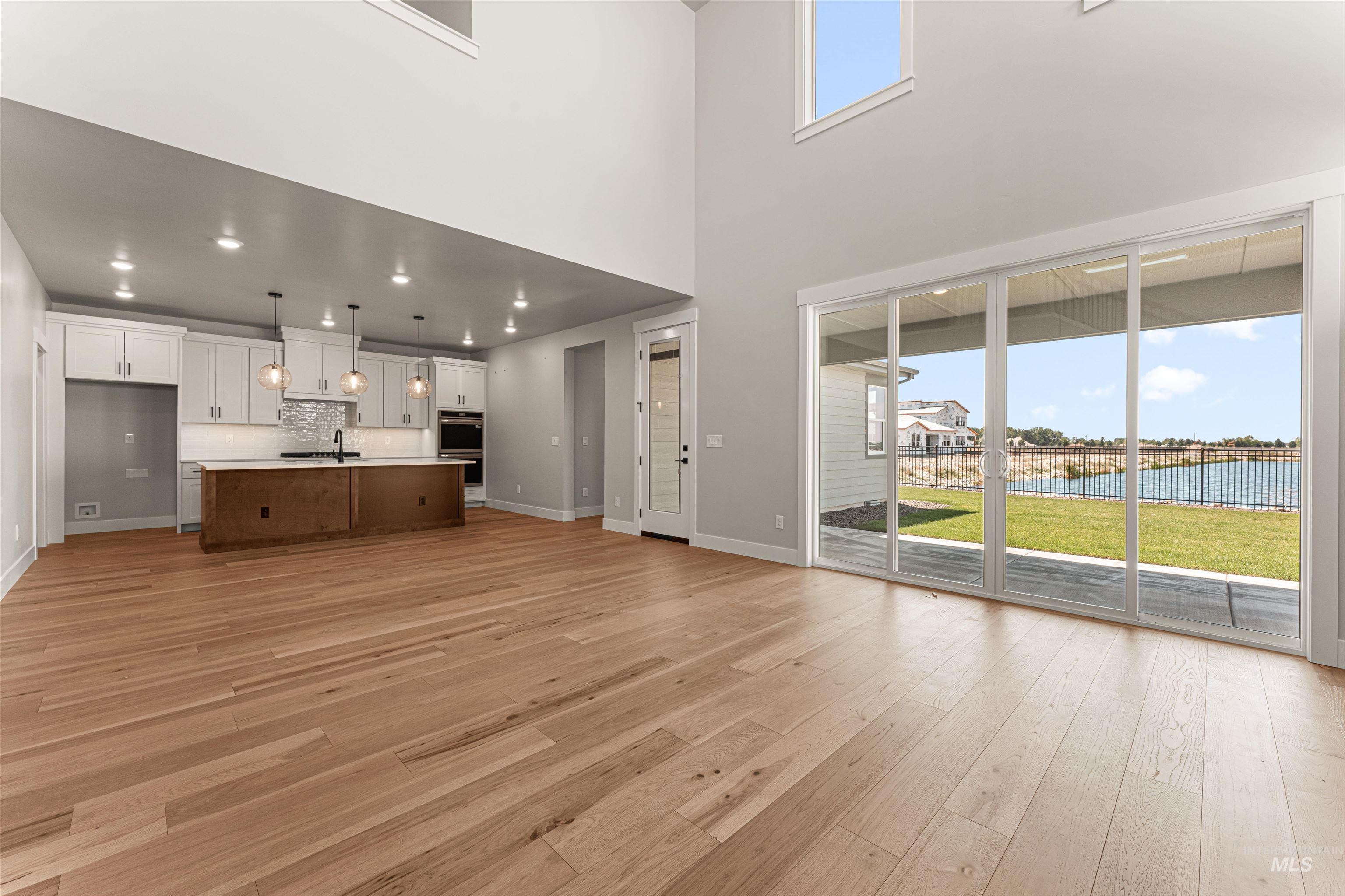 Unfurnished living room with light wood-type flooring and a water view
