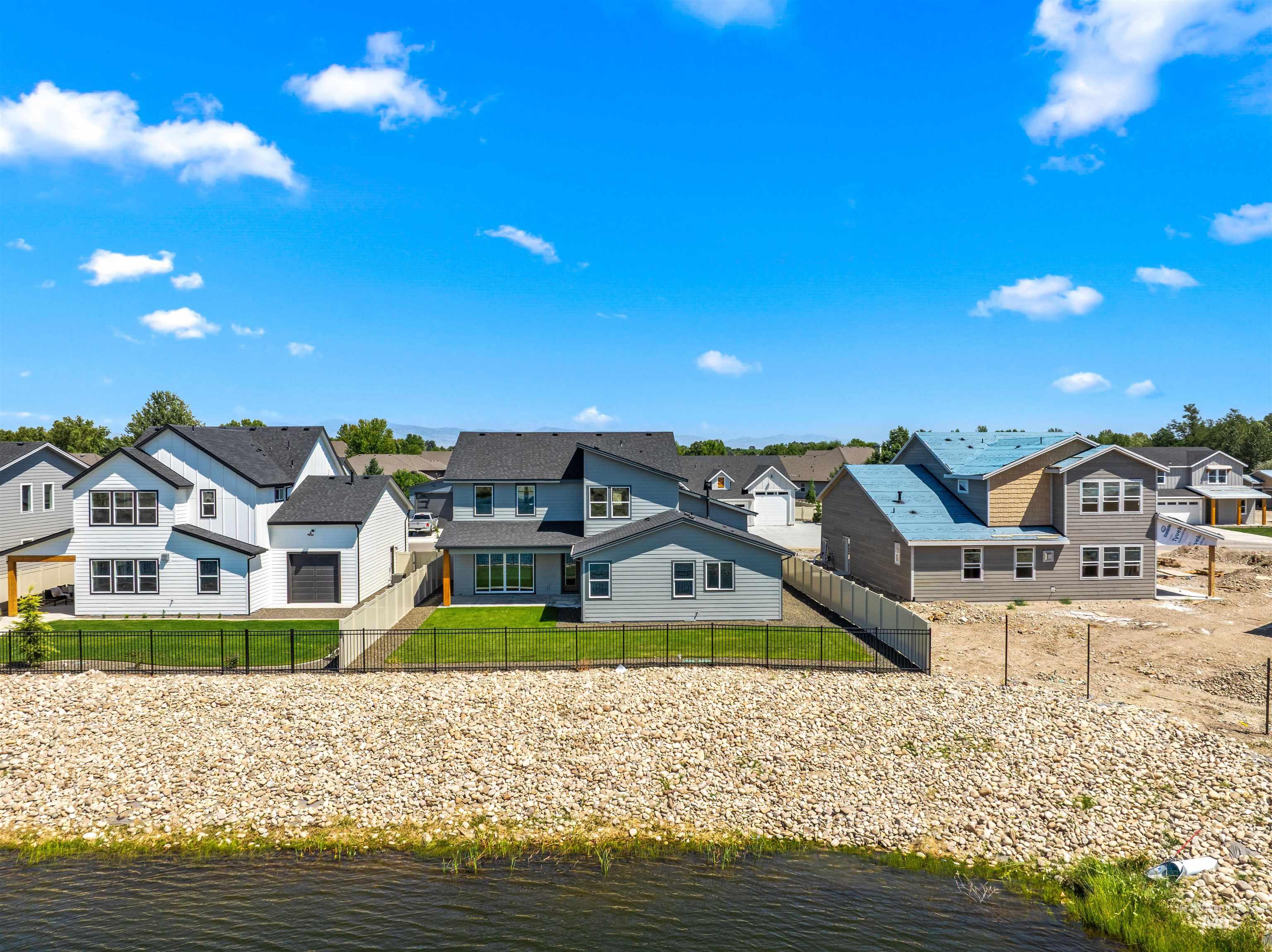 Rear view of house featuring a residential view, a water view, and a fenced backyard