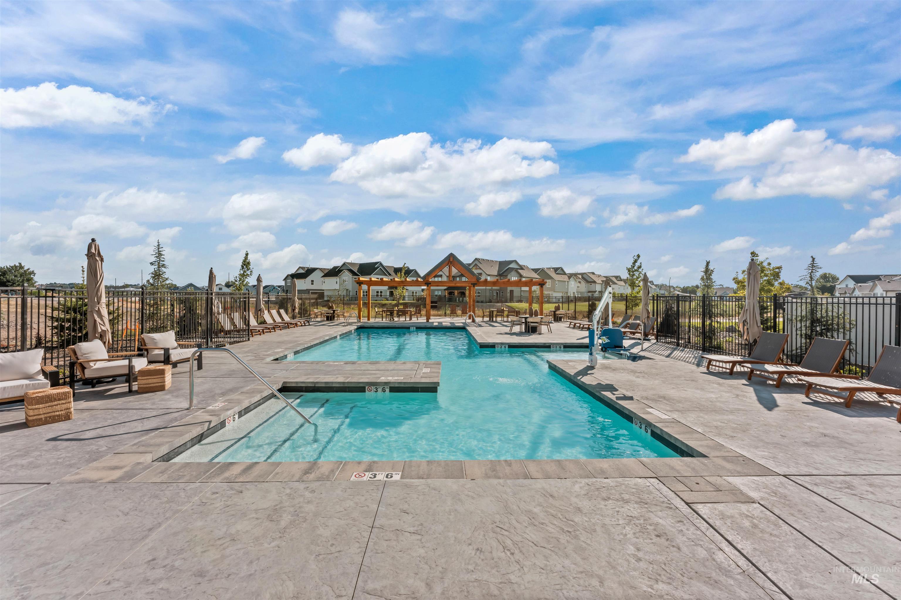 Community pool featuring a patio area and a residential view