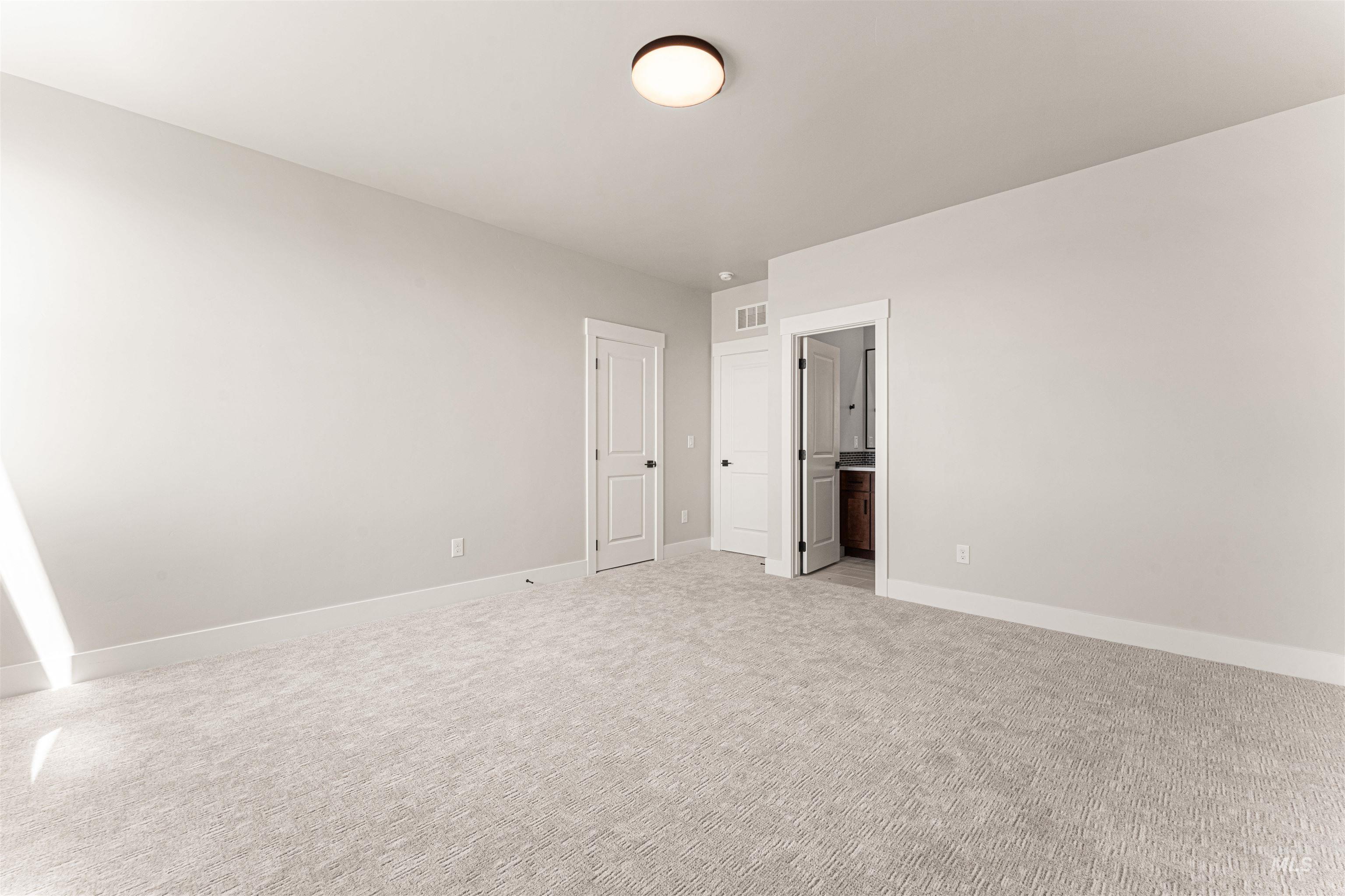 Unfurnished bedroom featuring light colored carpet and baseboards