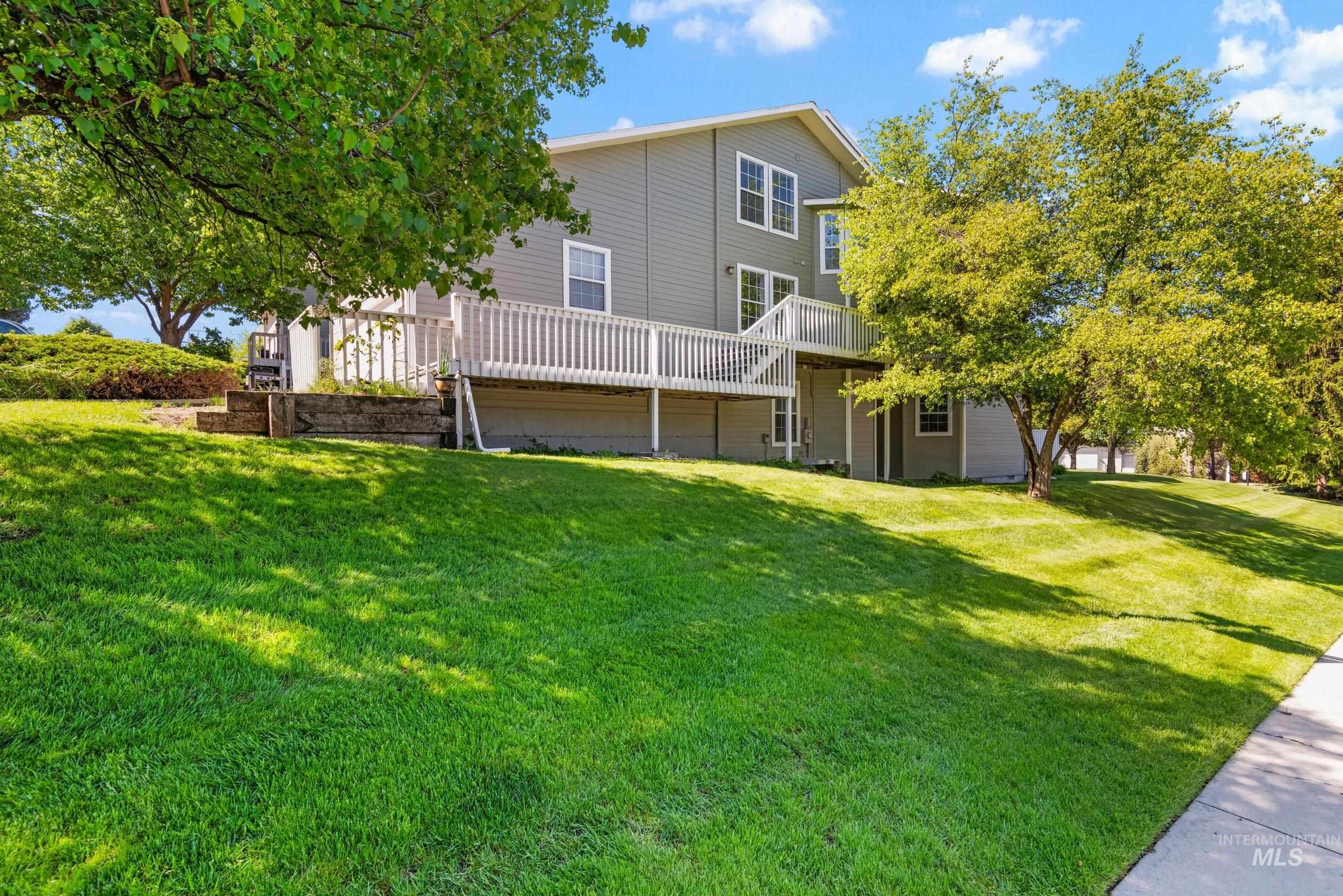 Back of property featuring a wooden deck and a yard