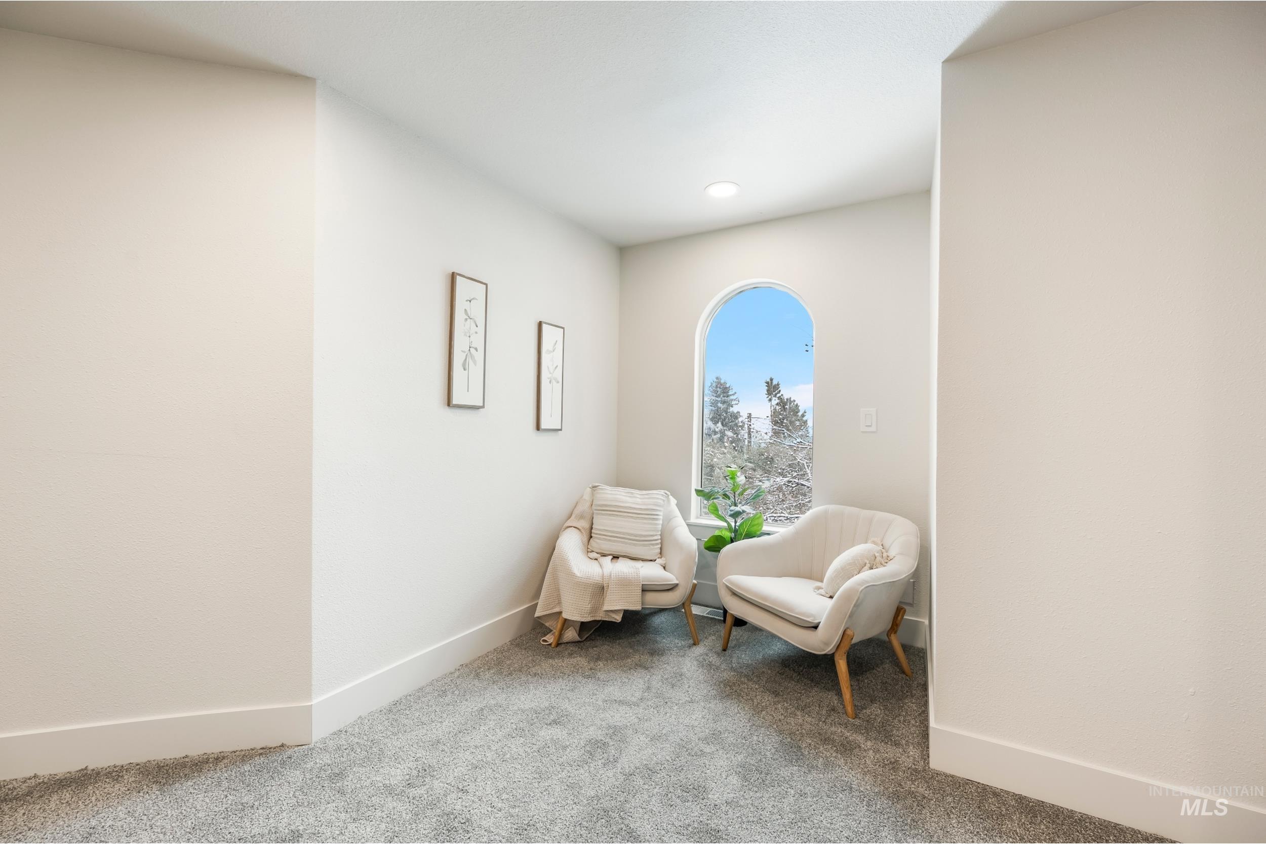 Sitting room with baseboards and carpet floors