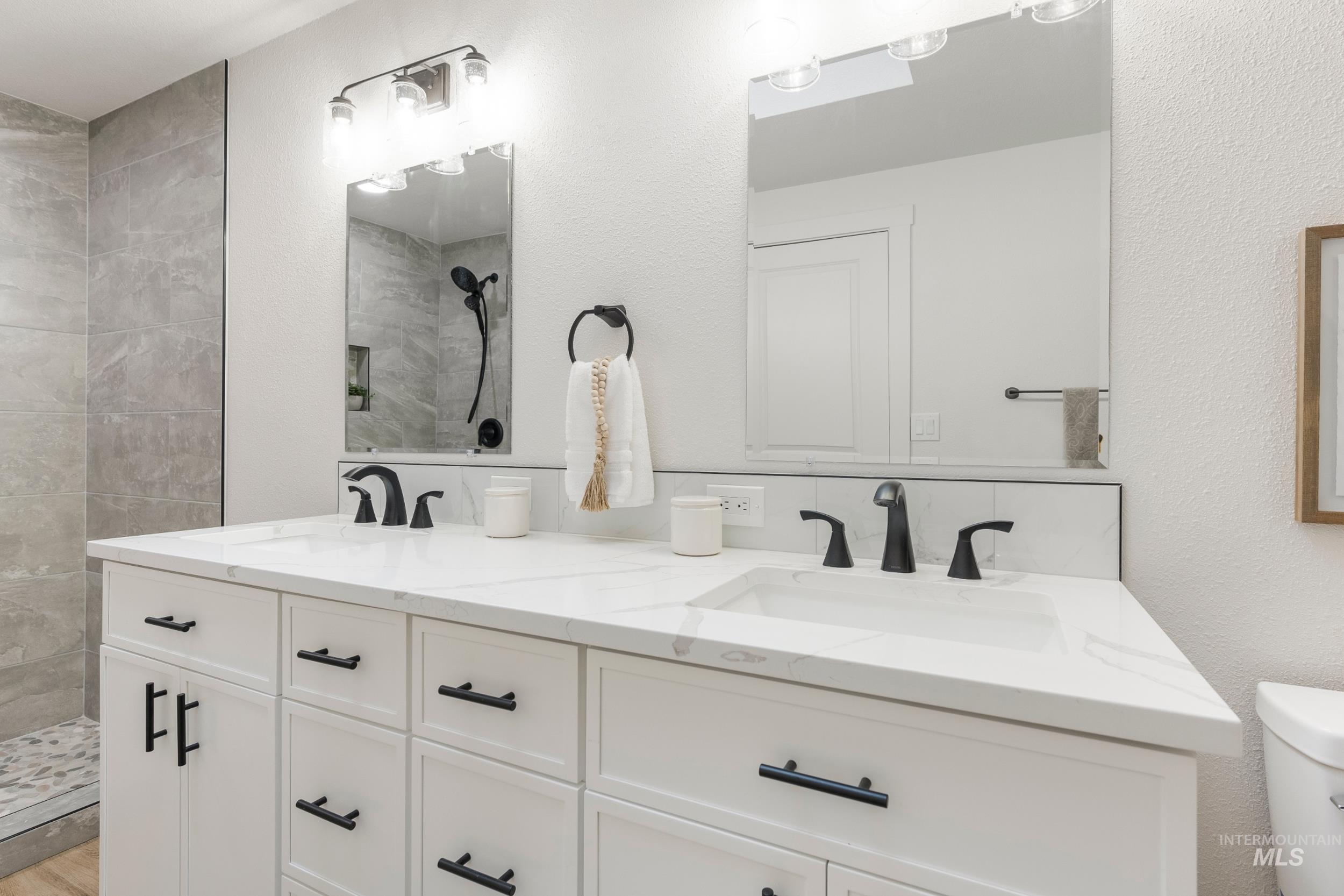 Full bathroom with a tile shower and a textured wall