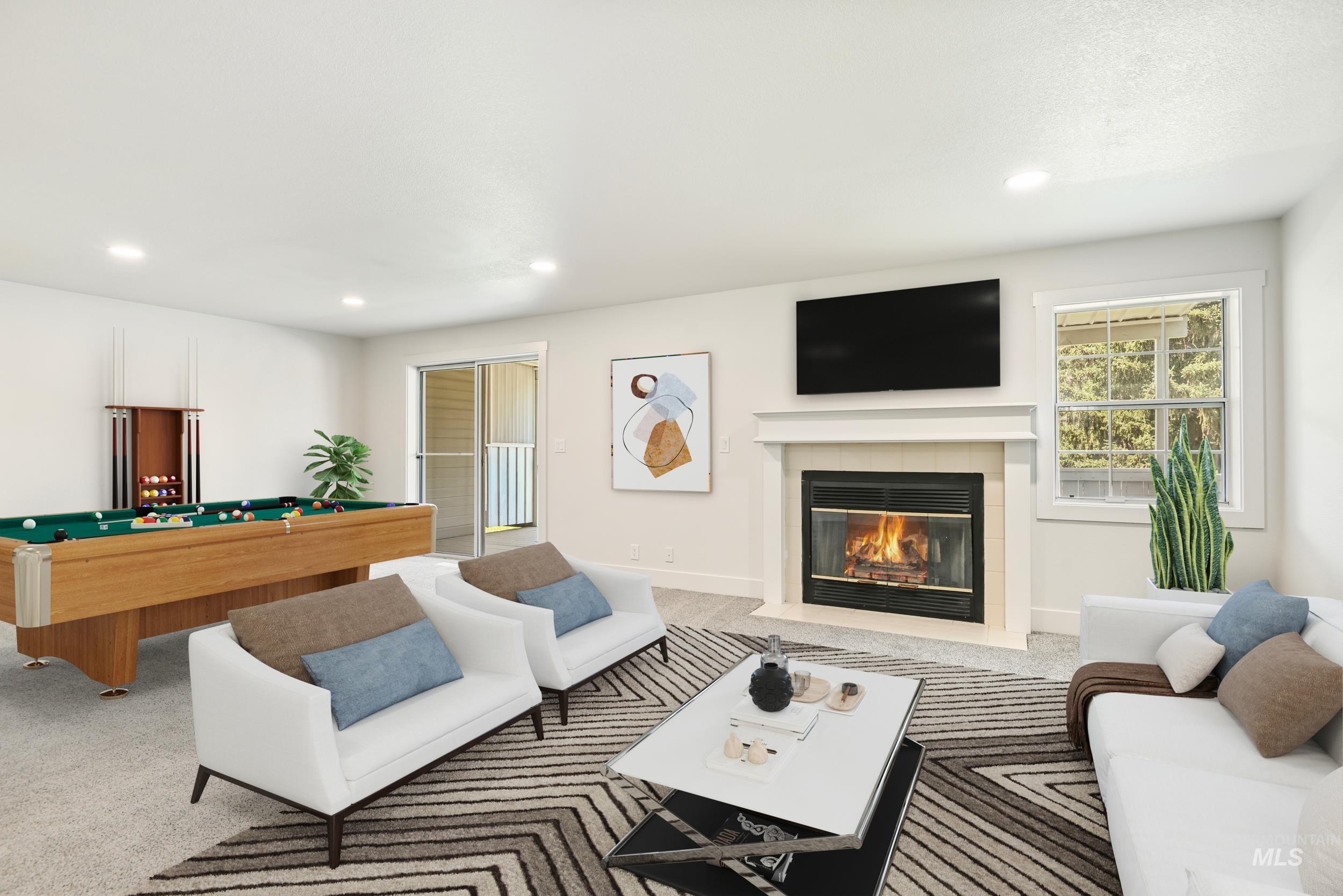 Living area featuring carpet, pool table, a tiled fireplace, and recessed lighting