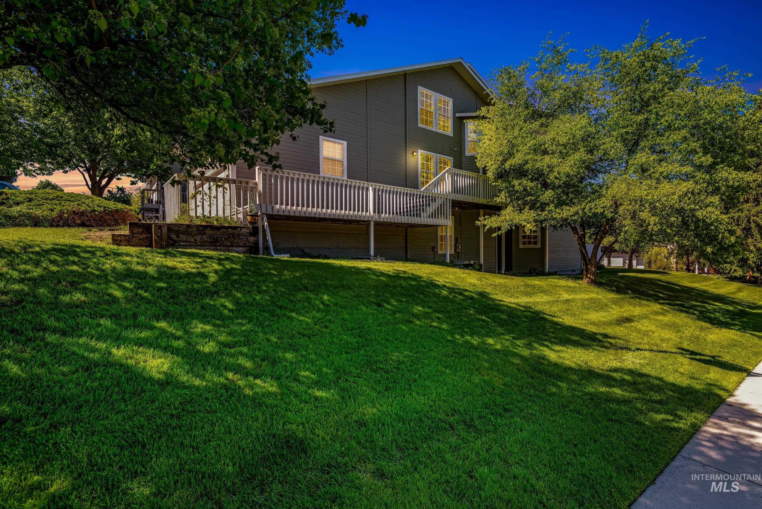 View of grassy yard featuring a wooden deck