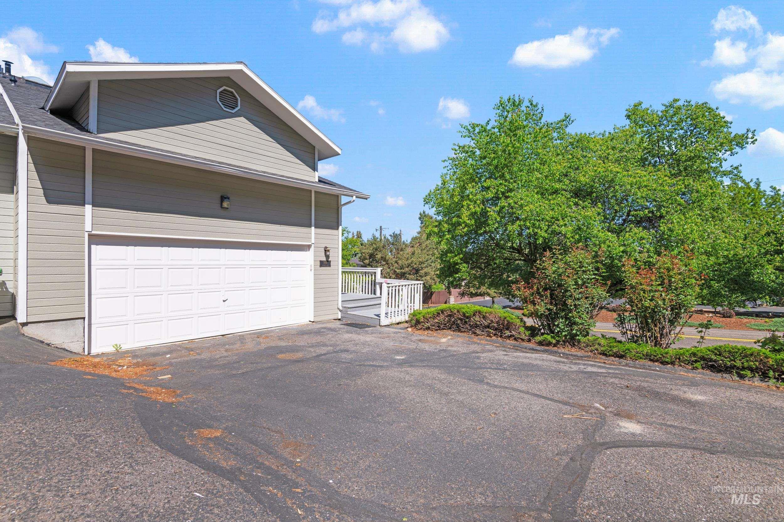 View of side of property with asphalt driveway and a deck